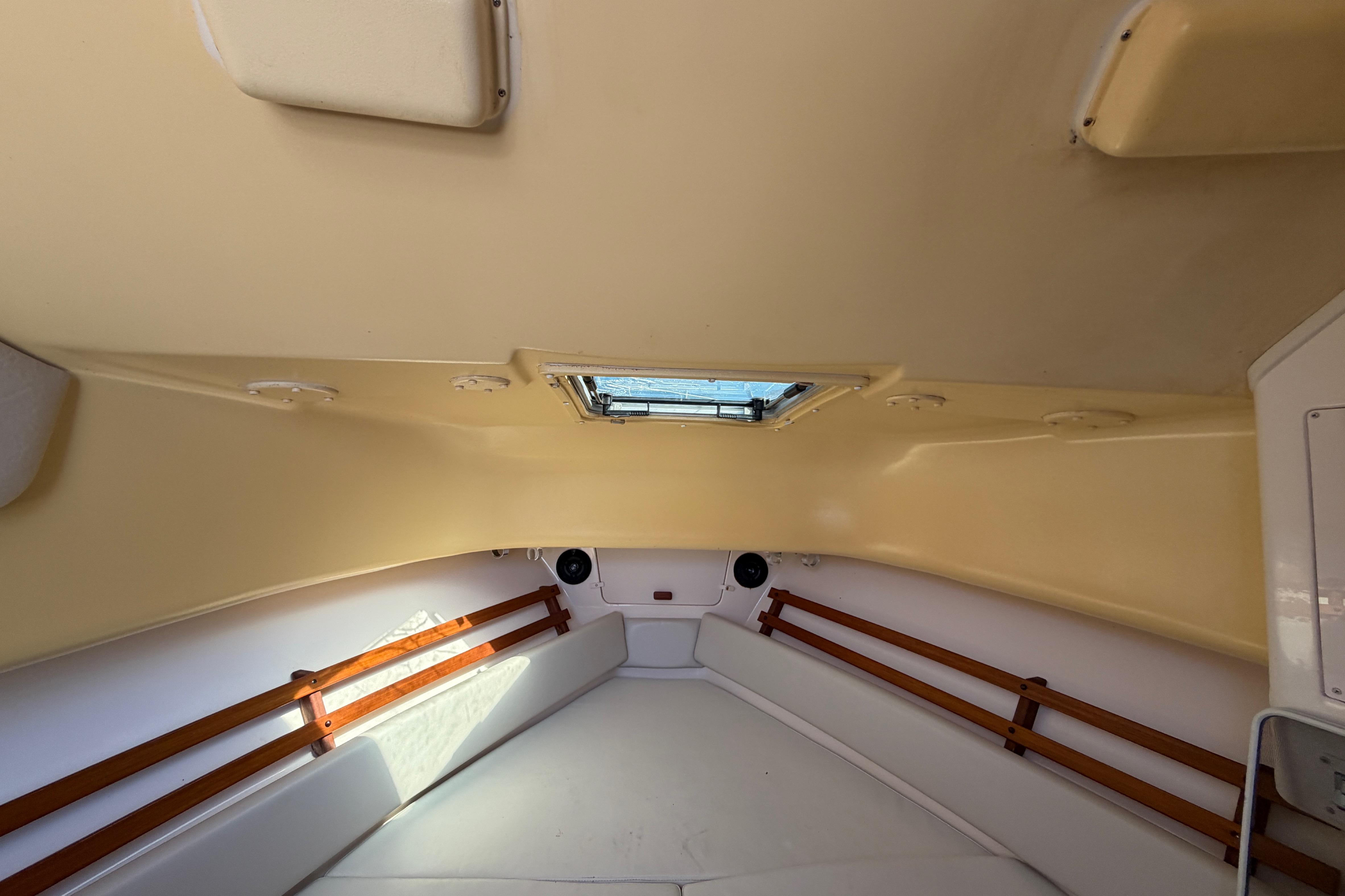 Interior cabin of 2006 Grady-White Sailfish 282 boat, featuring cozy seating and wooden accents.