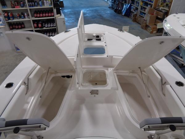 2023 Robalo 246 Cayman boat with open storage compartments inside.