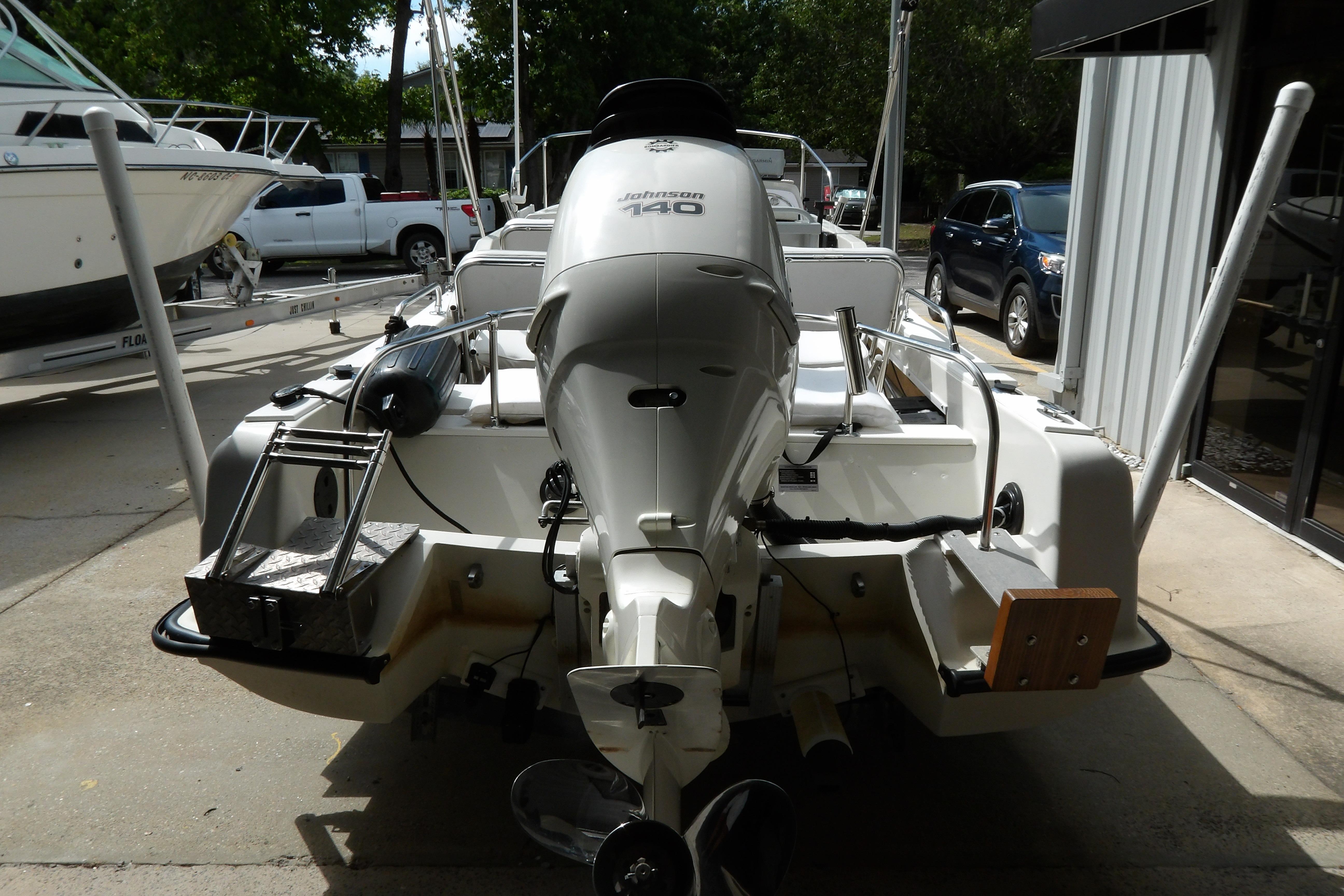 1978 Boston Whaler 21 Revenge with Johnson 140 outboard motor, parked outdoors.