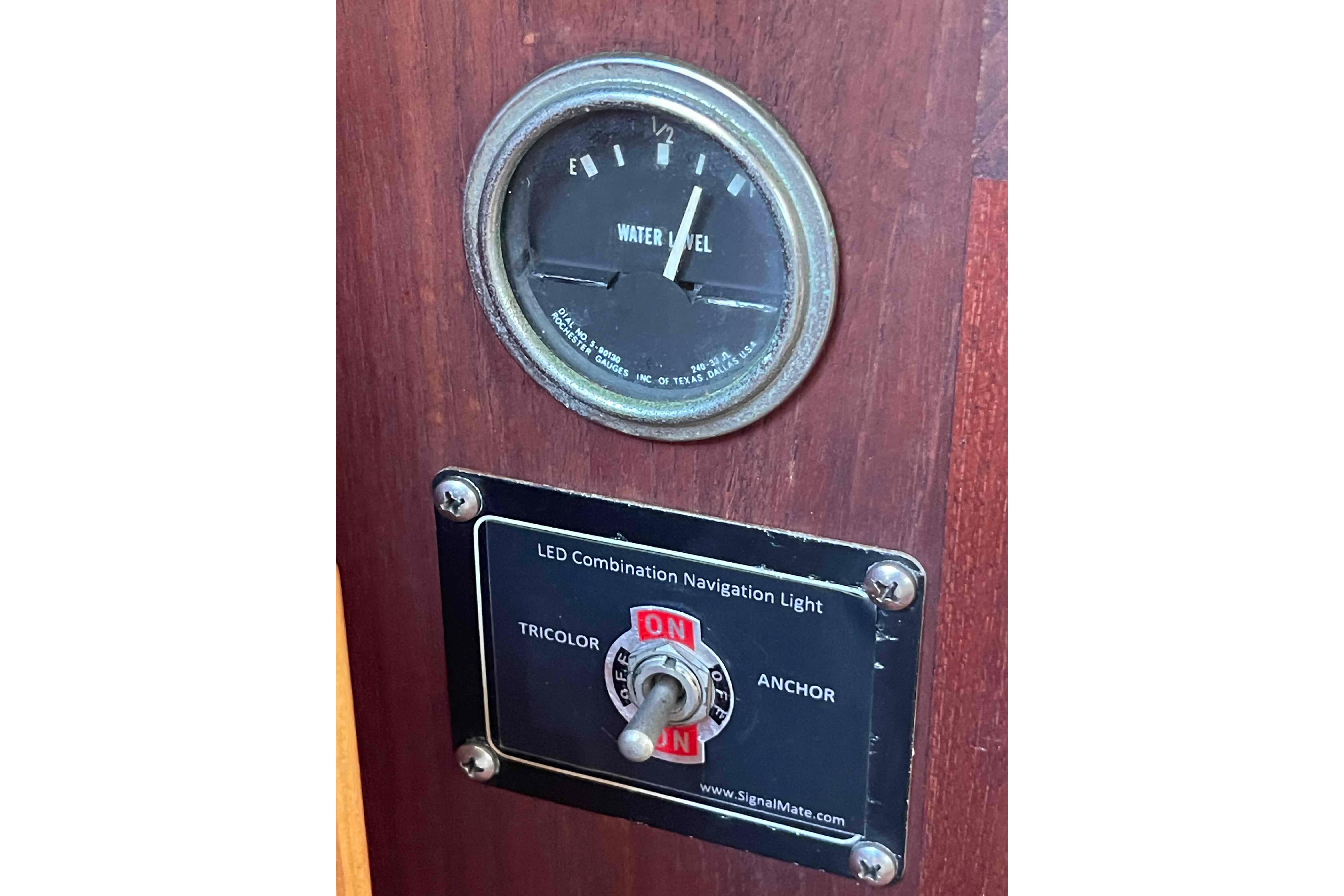 Control panel of 1989 Island Packet 35 with water level gauge and navigation light switch.
