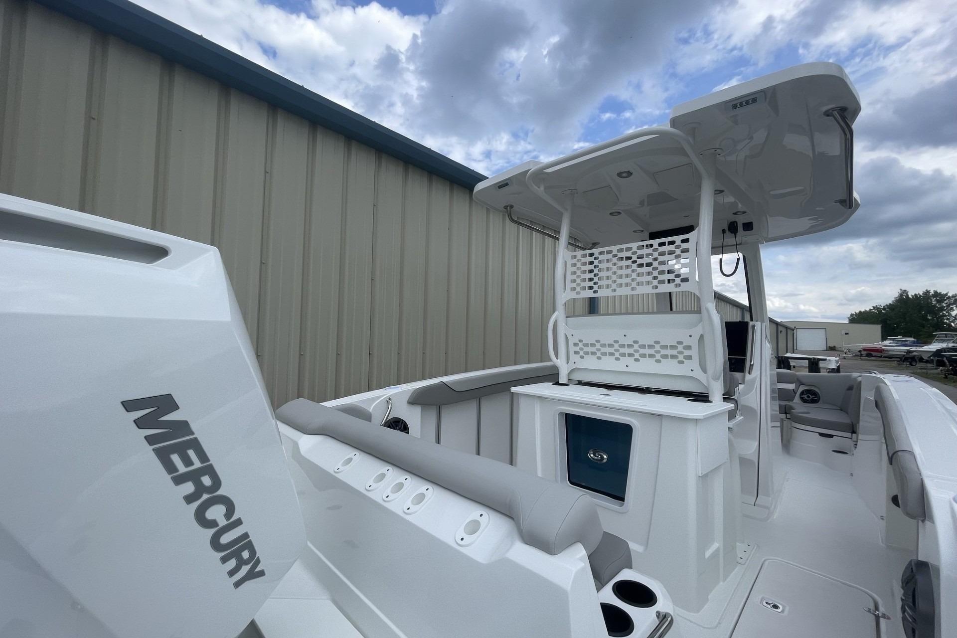 2026 Hurricane Center Console 24 OB boat with Mercury engine, docked under cloudy sky.