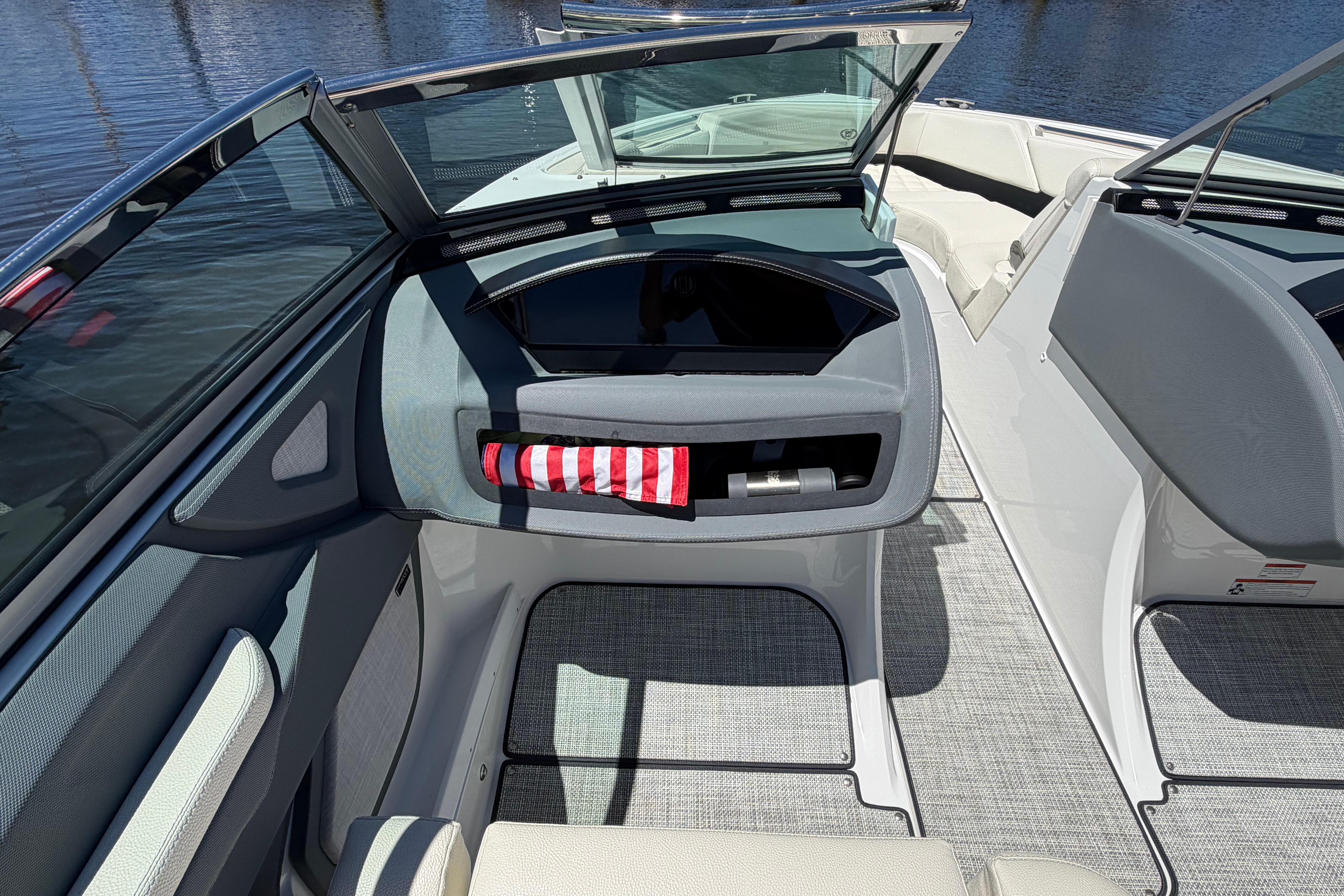 2020 Cobalt R3 boat interior with open windshield and striped towel, docked on water.