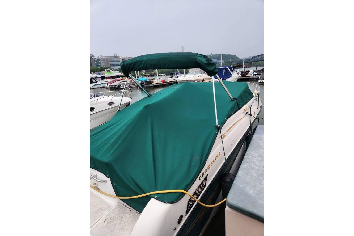 2001 Crownline 242 CR boat with green cover docked at marina.