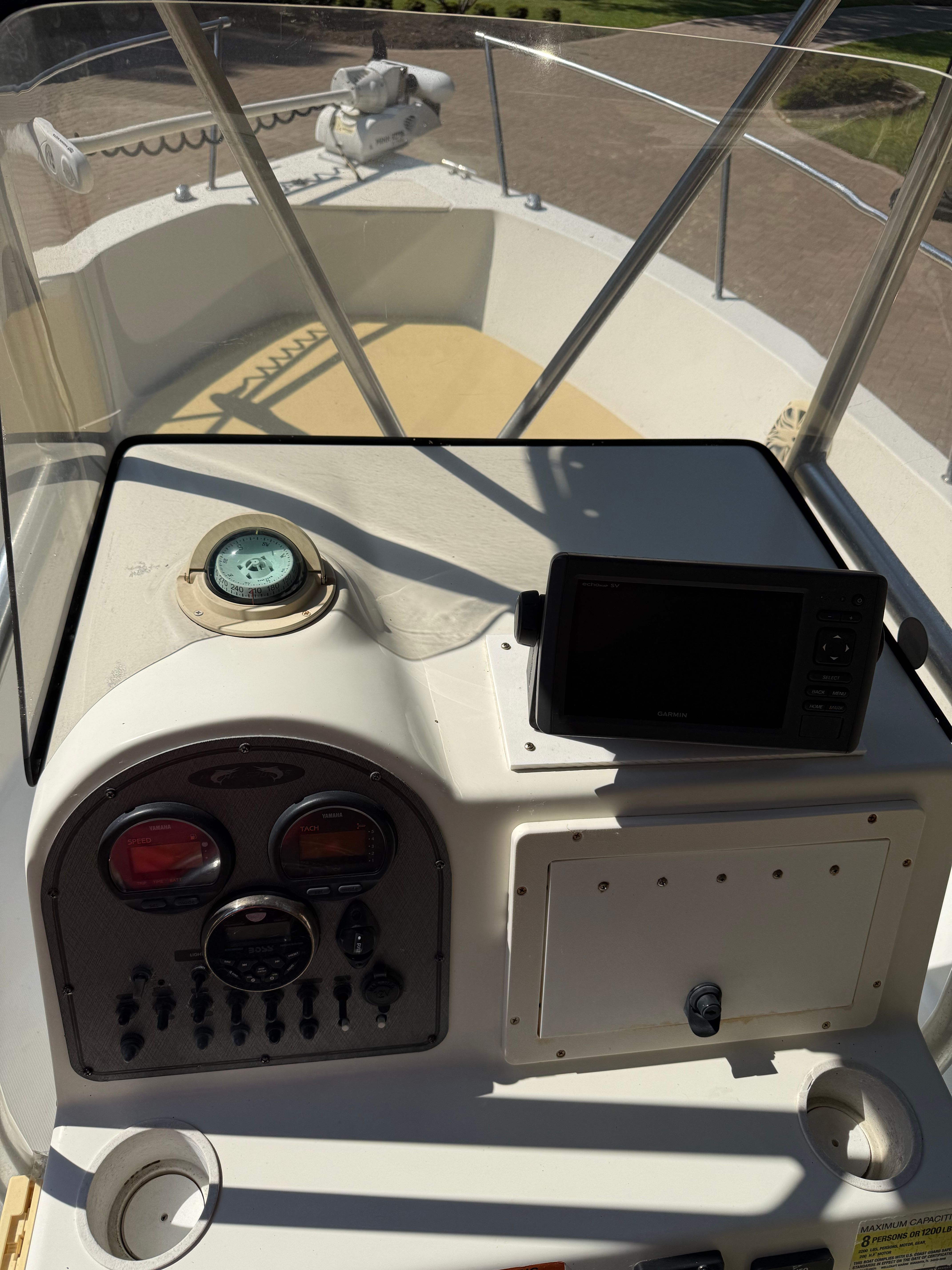 The cockpit of a boat with controls and a navigation system.