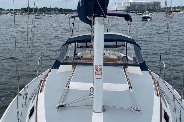 1989 Catalina 30 sailboat on calm water with other boats in the background.