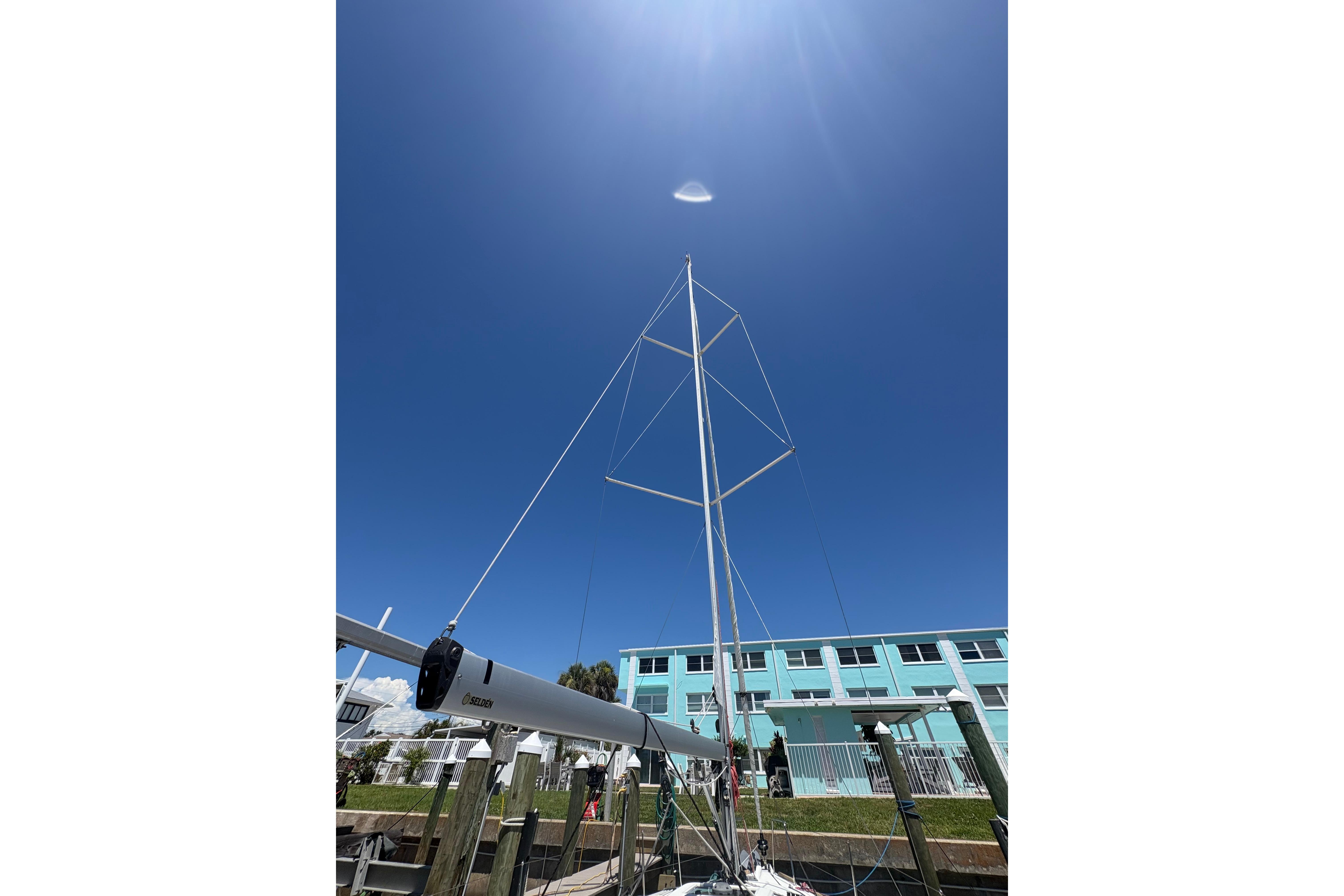 Jeanneau Sun Odyssey 349 sailboat mast against clear blue sky, 2021 model.