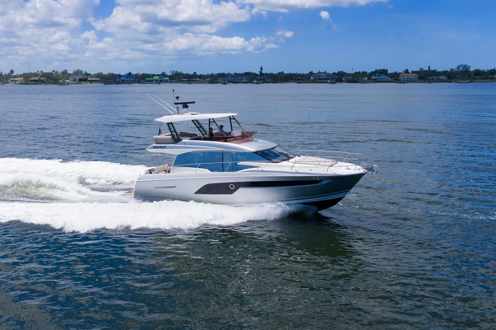 2022 Prestige 520 yacht cruising on open water under a clear blue sky.