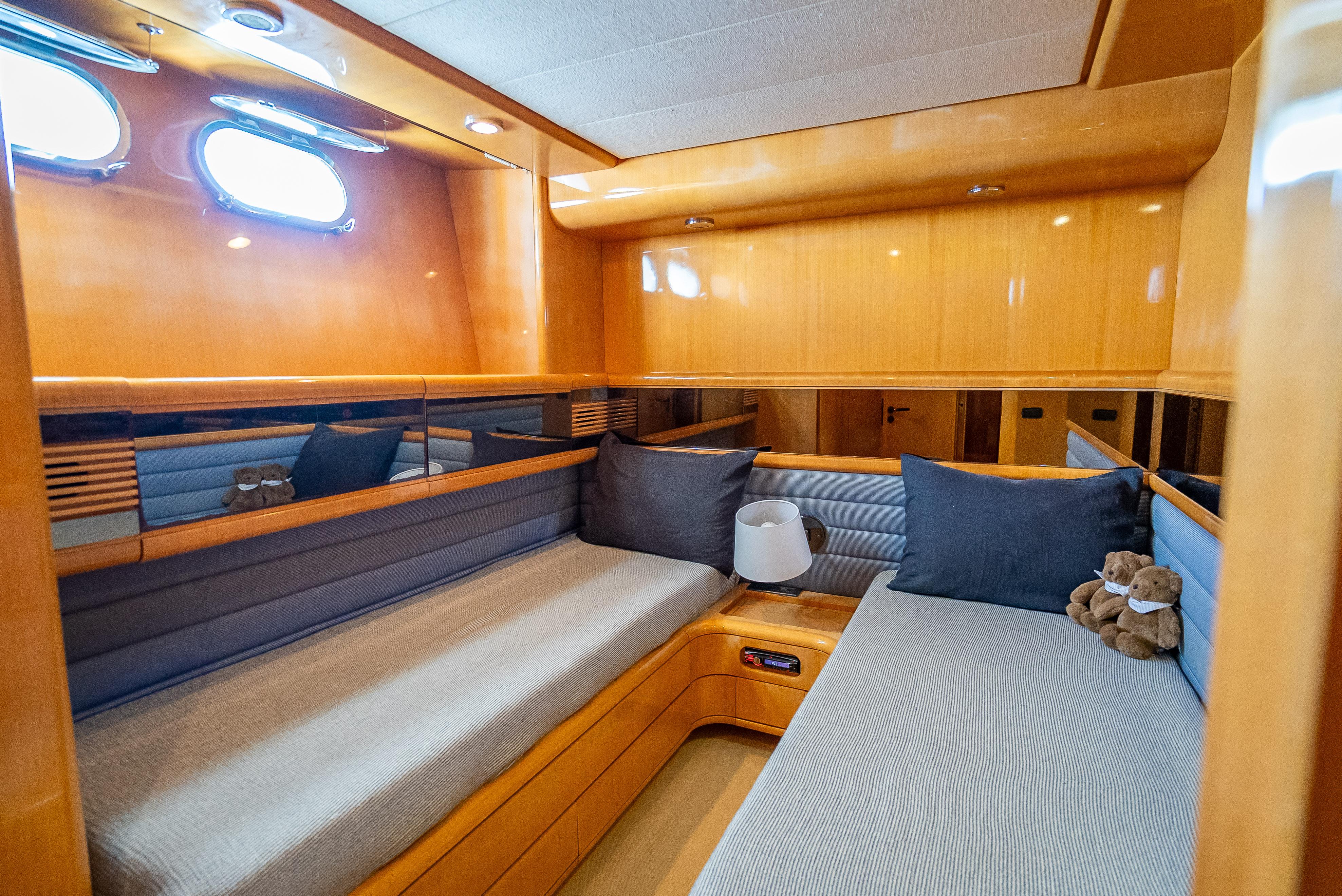 Luxurious cabin interior of 1995 Sanlorenzo 62 yacht with cozy seating and elegant wood finish.