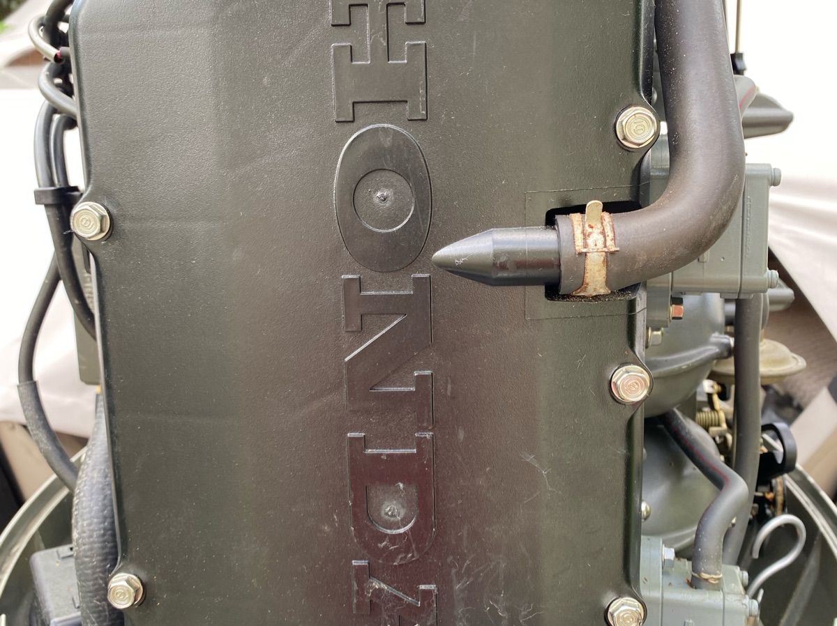 Close-up of a Honda boat engine with visible hoses and bolts.