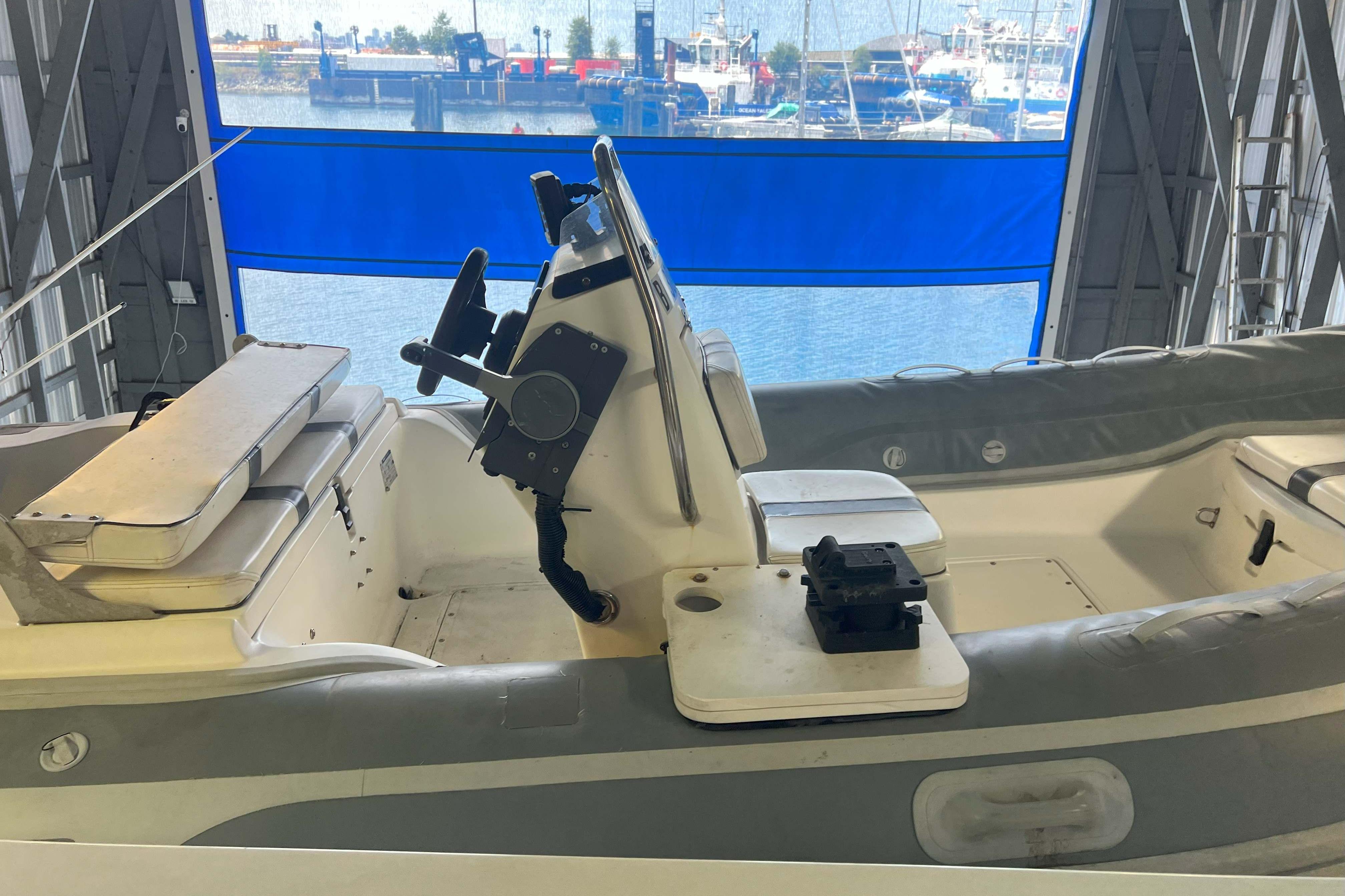 1998 West Bay 58 boat interior with steering console and seating in a marina setting.