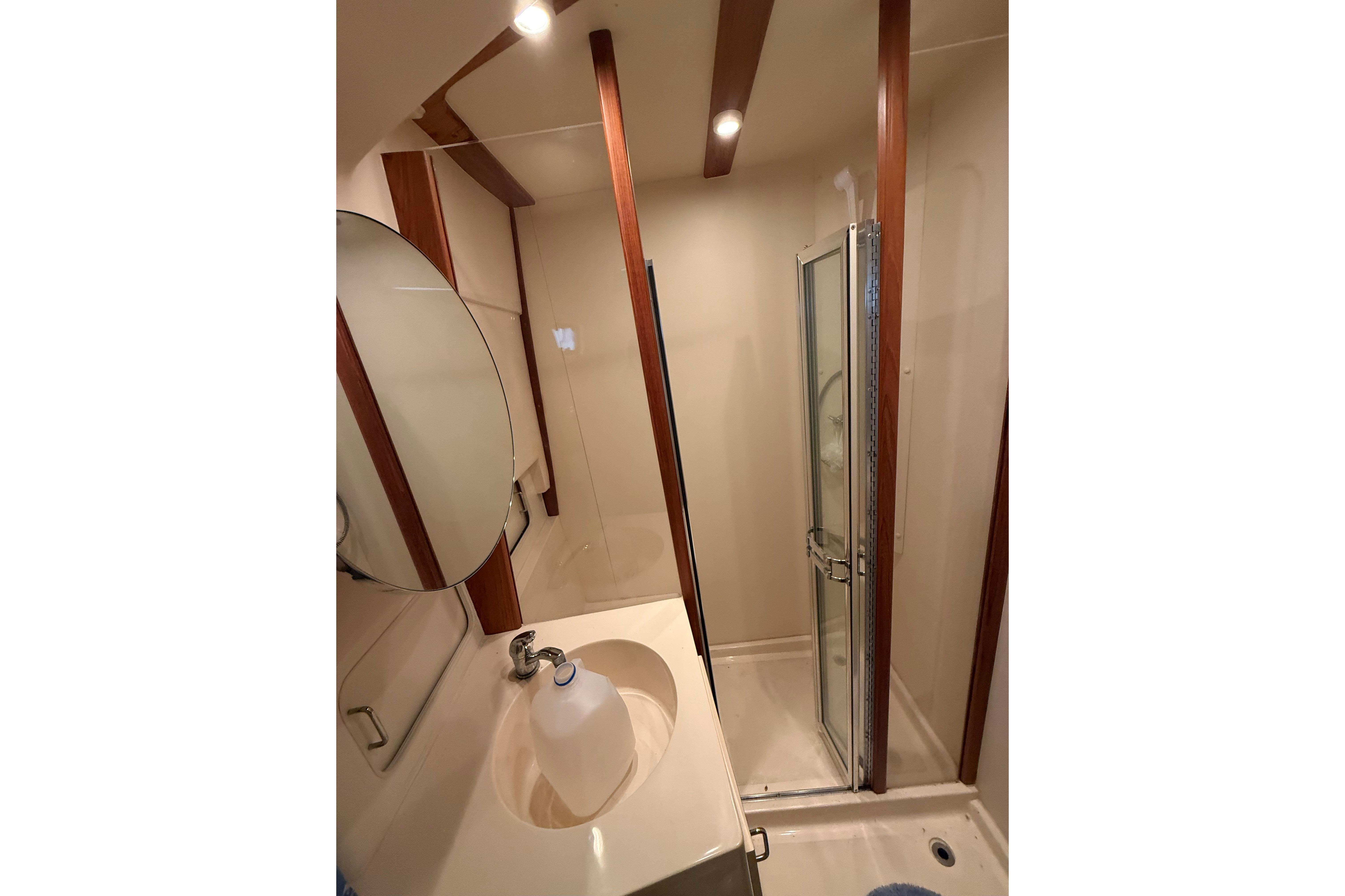 Bathroom interior of 1999 Mainship 350 Trawler with shower and sink.