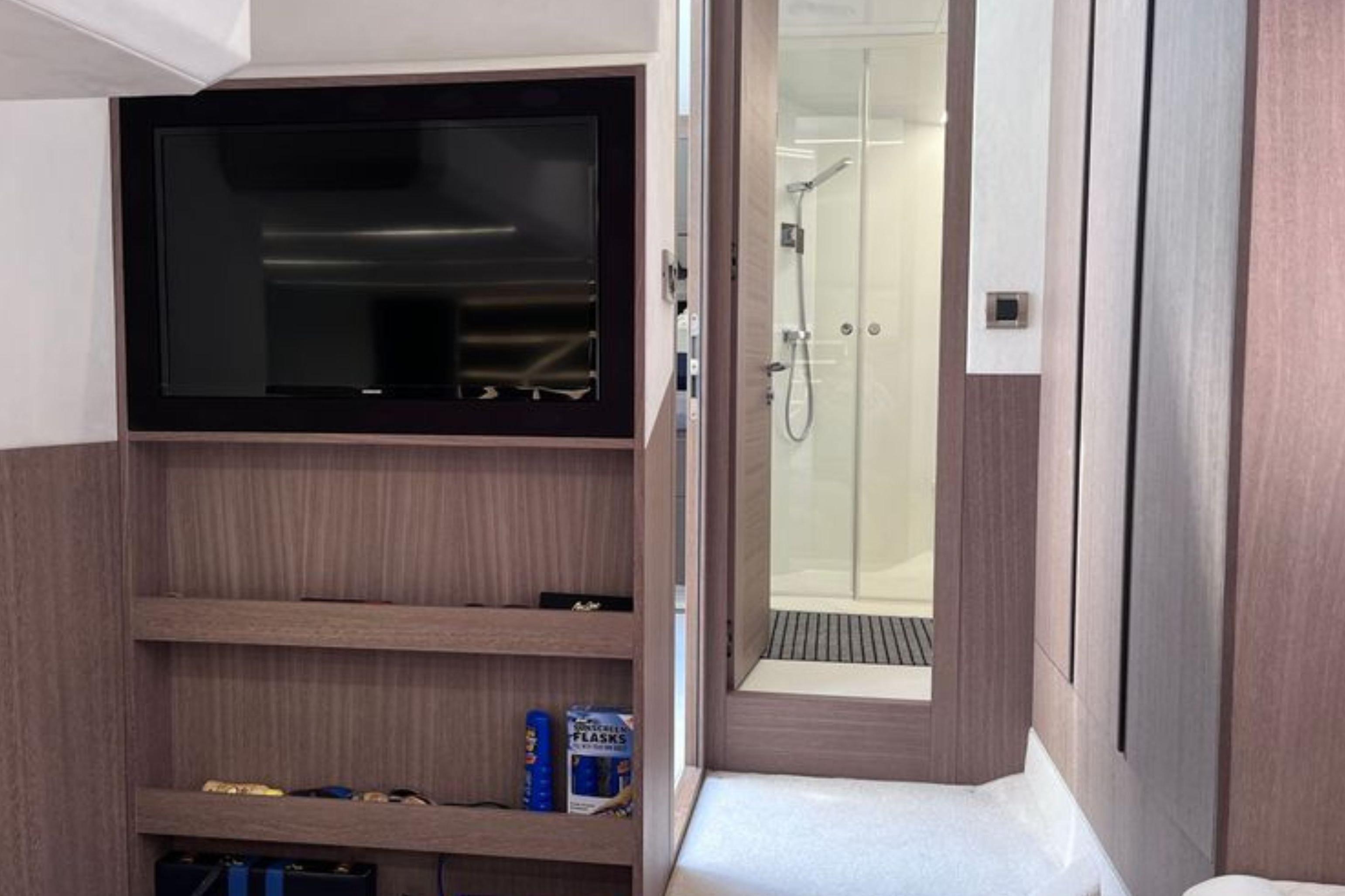 Interior of 2024 Galeon 425 HTS yacht with TV and modern bathroom.
