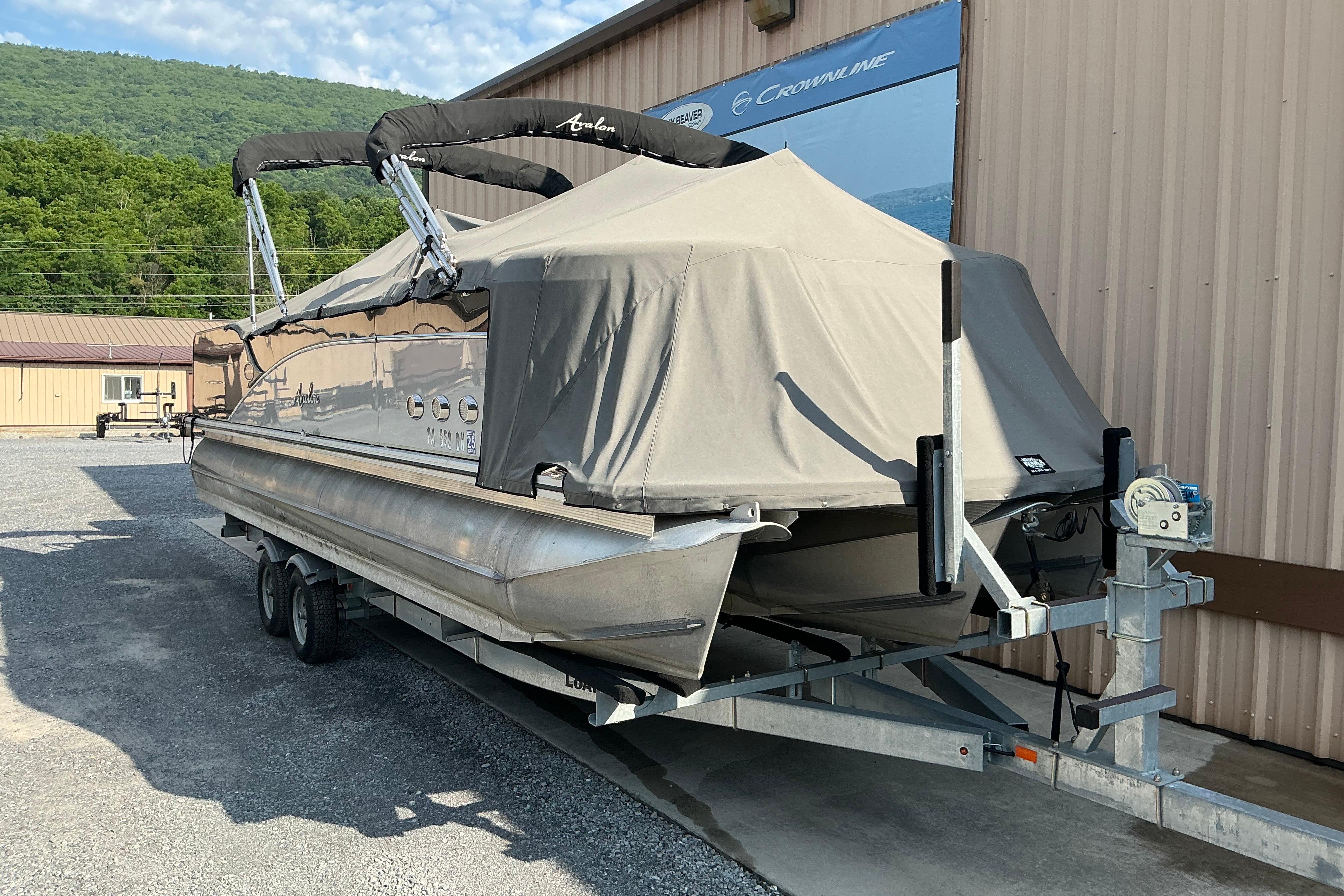 2014 Avalon 25 ft. Paradise Elite pontoon boat covered on trailer.