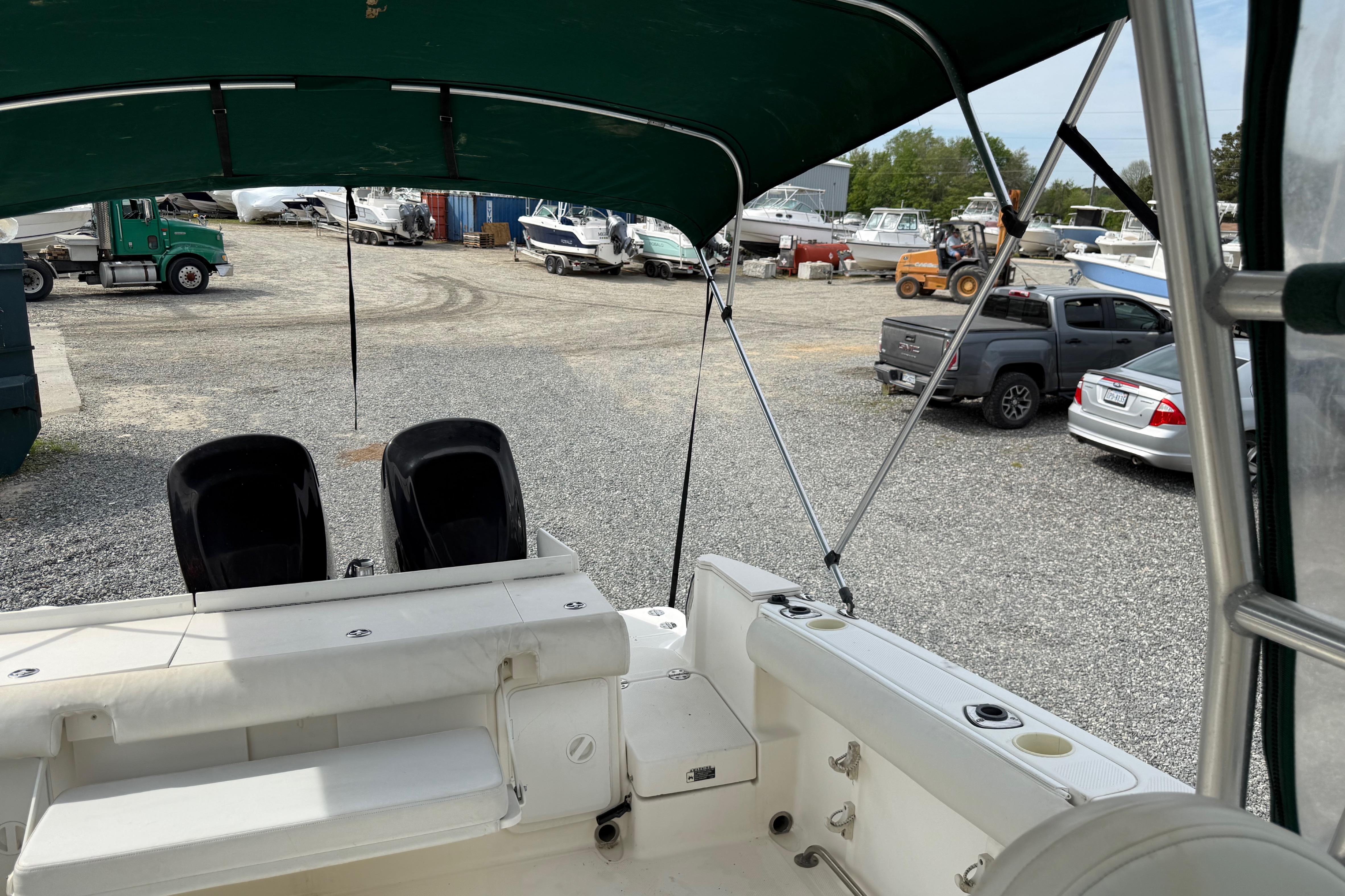 2006 Trophy 2502 Walkaround boat interior with canopy, parked in a gravel lot.