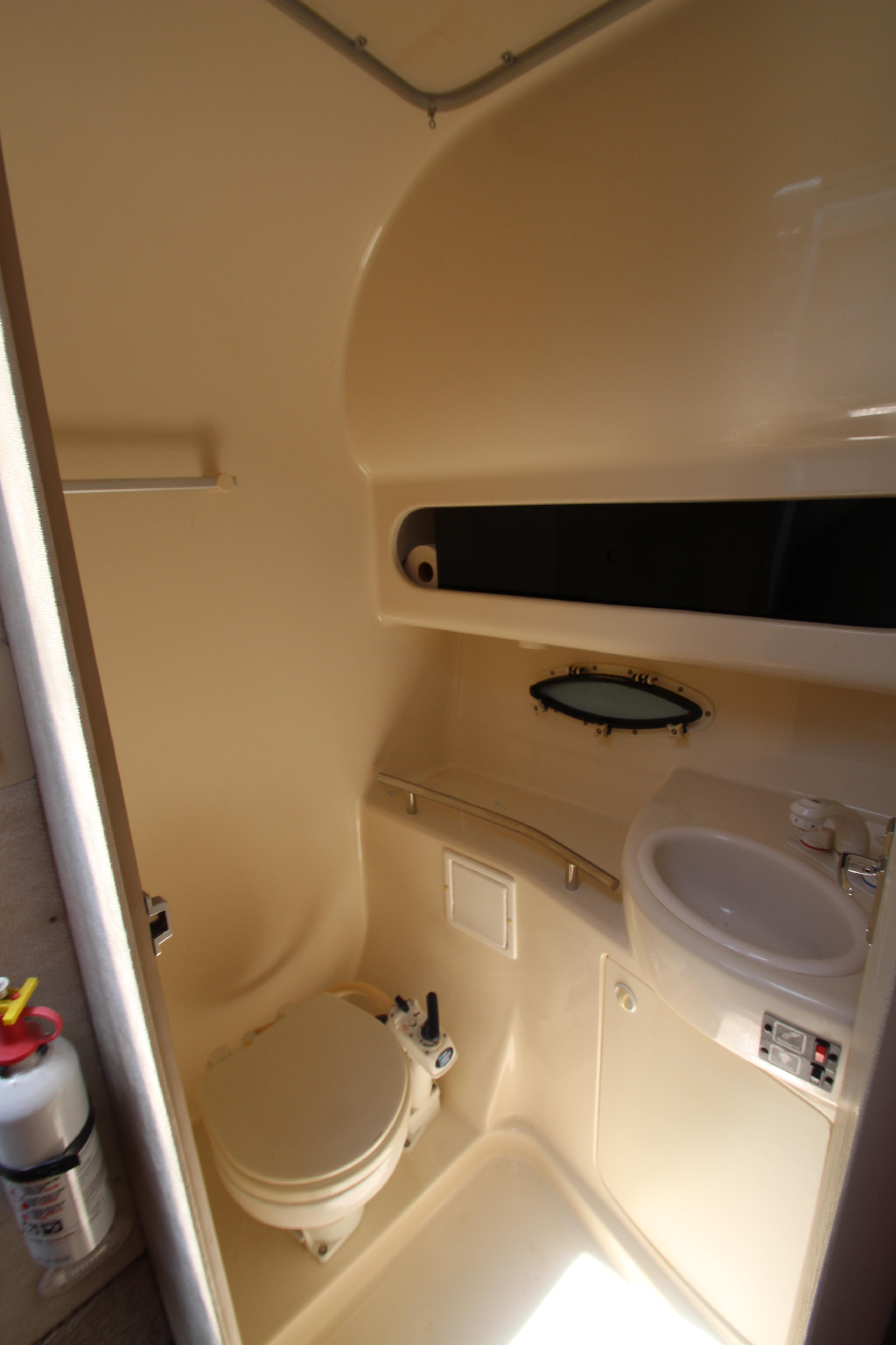 1999 Bayliner 3055 Ciera boat bathroom with toilet, sink, and storage.