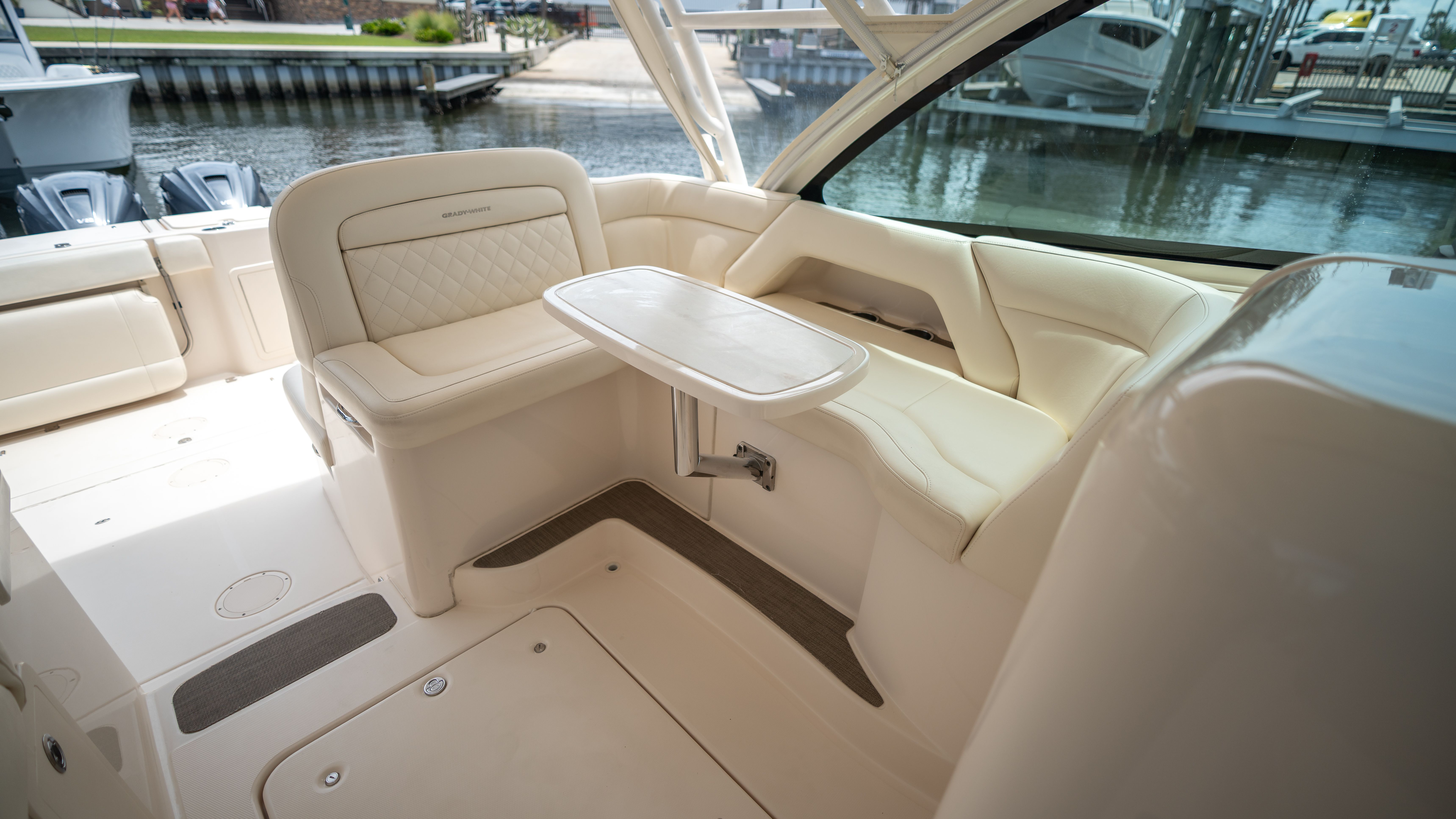 Interior of a Grady-White 375 Freedom with beige upholstered seating and table.