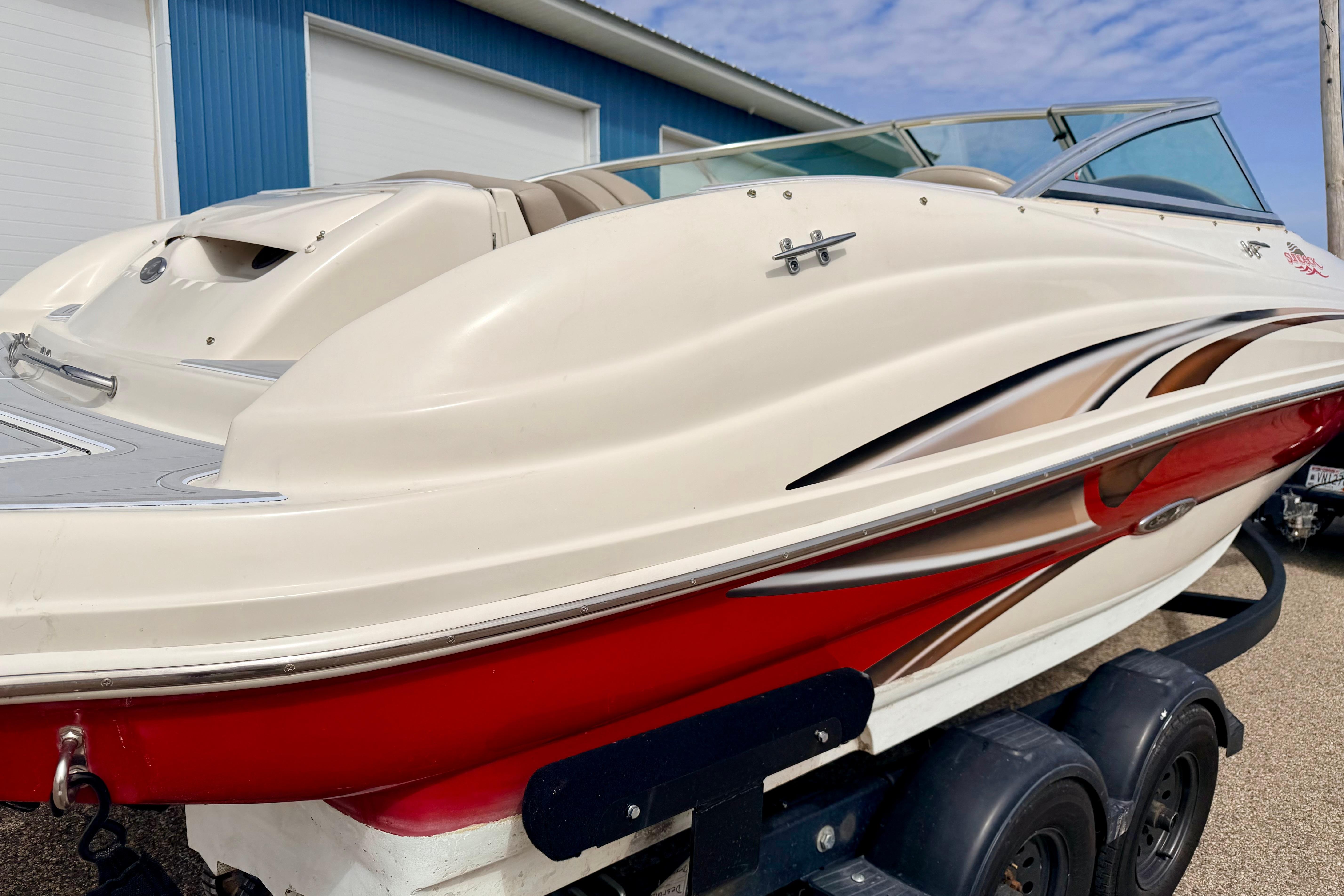 2003 Sea Ray 200 Sundeck boat with red and white design on a trailer.