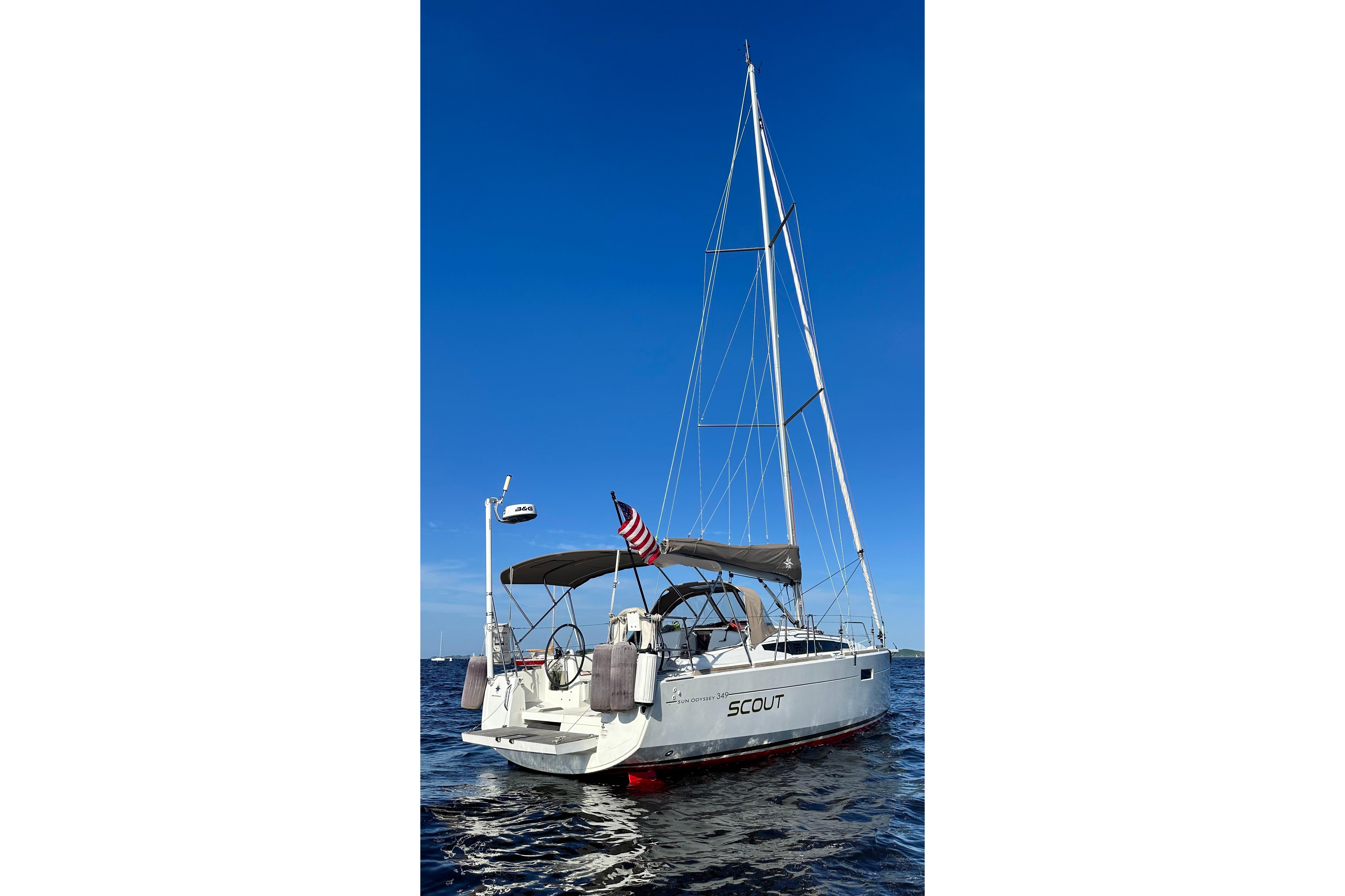 2016 Jeanneau Sun Odyssey 349 sailboat on open water under clear blue sky.