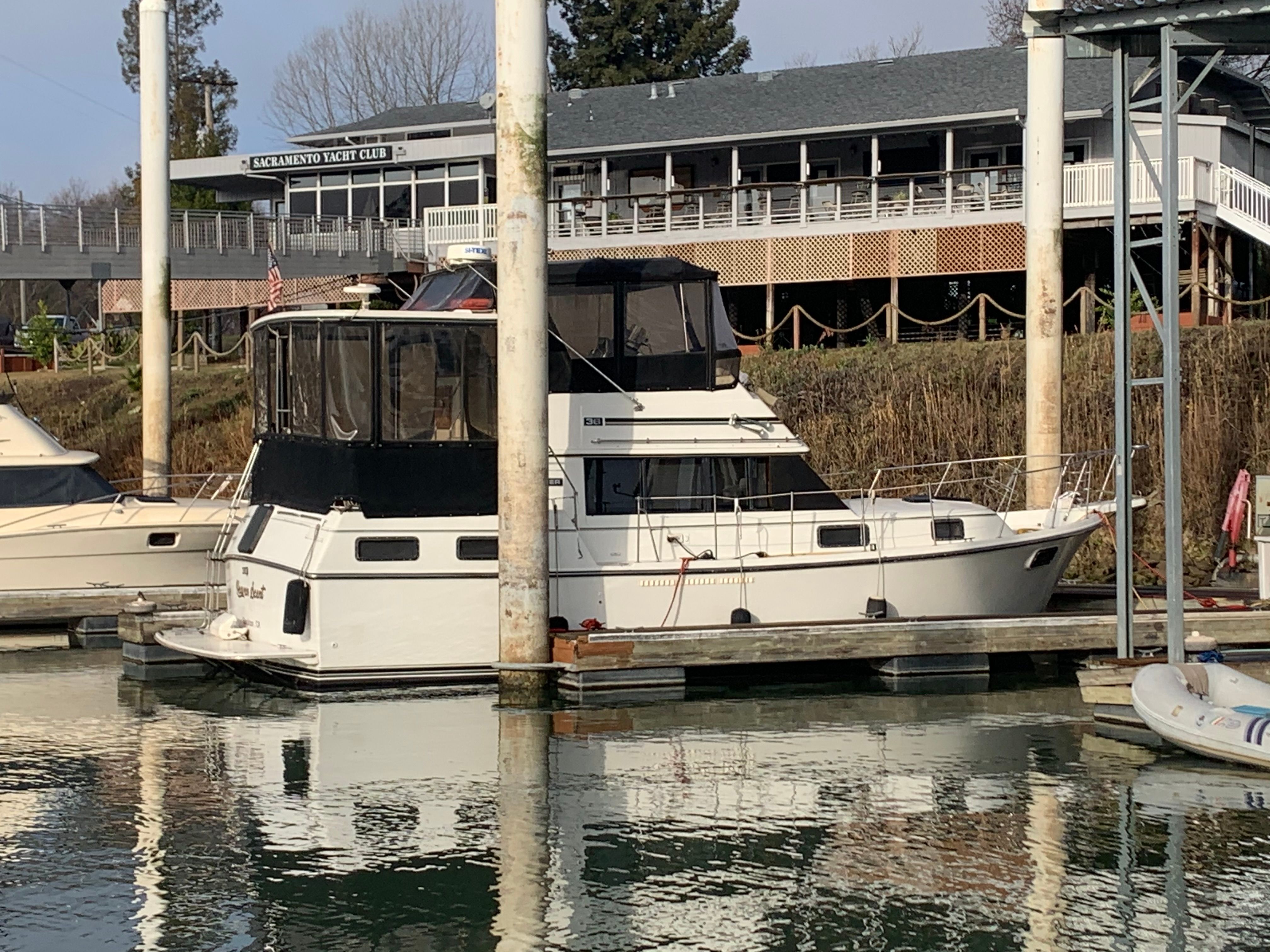 A 1988 Carver 3607 Aft Cabin Motor Yacht docked near a yacht club.