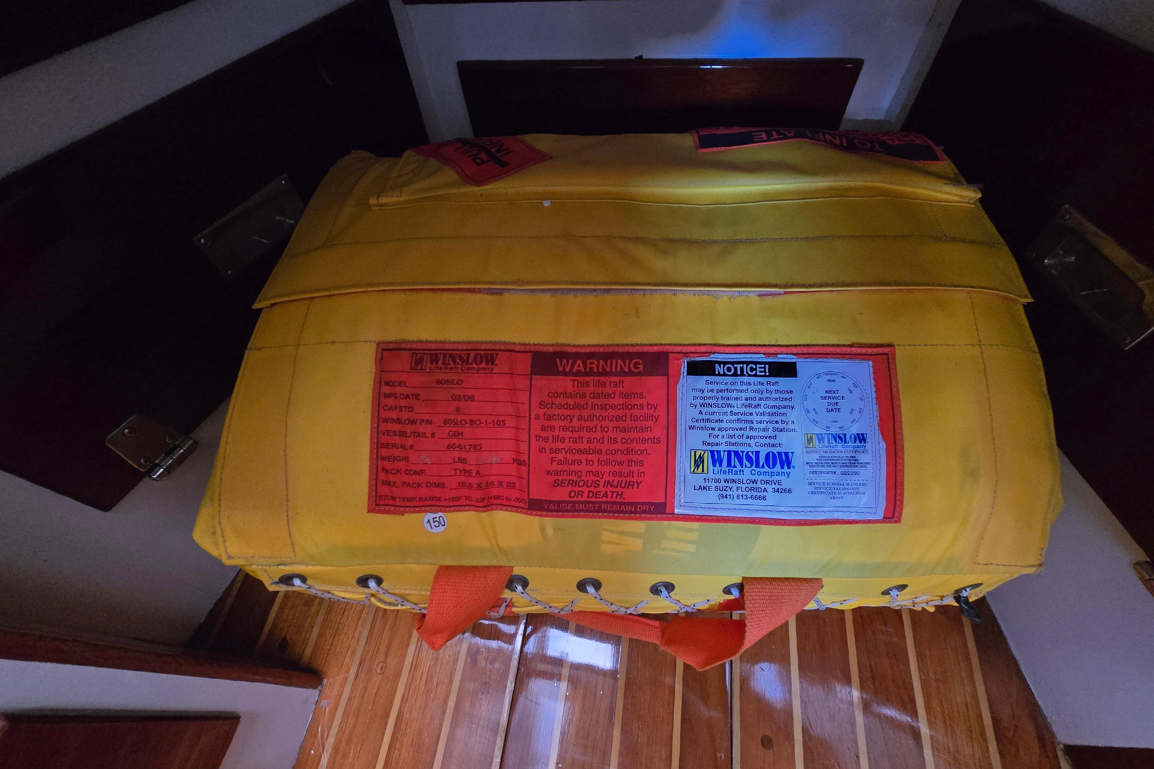 Yellow Winslow life raft on 1970 Hinckley Bermuda 40 yacht, featuring safety warnings and notices.