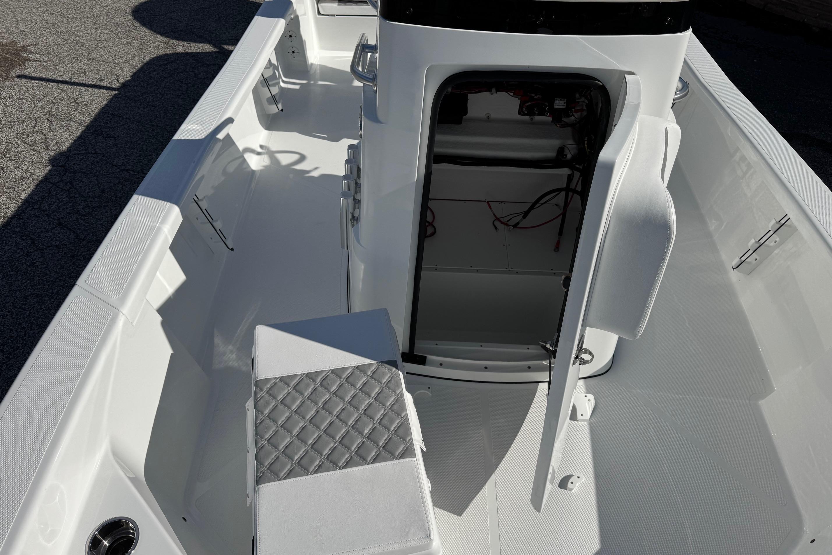 2026 BlackJack 256 Bay boat interior with open storage compartment and cushioned seating.