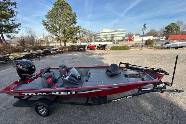 2025 Tracker Pro Team 190 boat in parking lot, red exterior, equipped with motor.