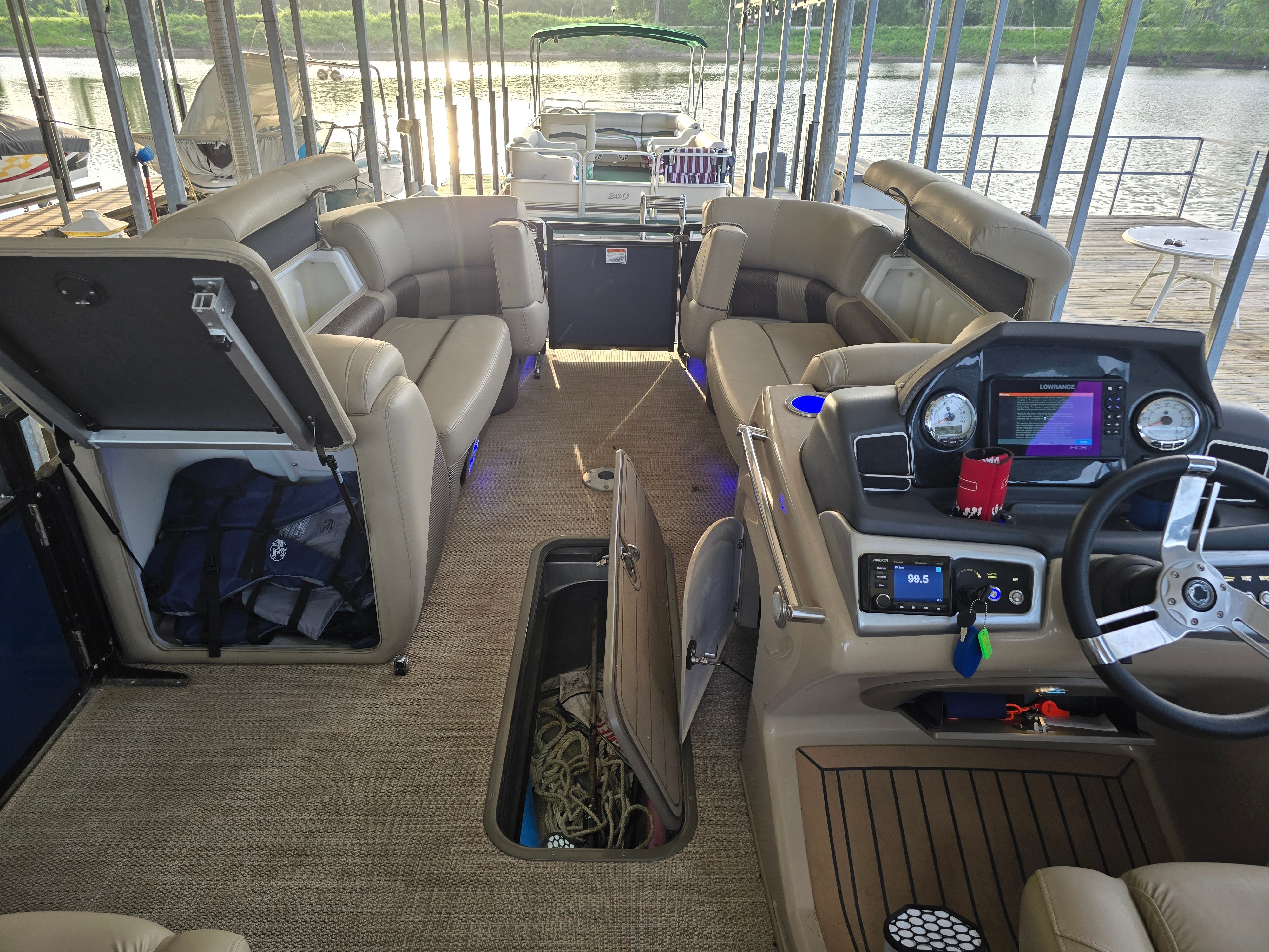 Interior of a 2021 Regency 230 LE3 with beige seating and a helm console.