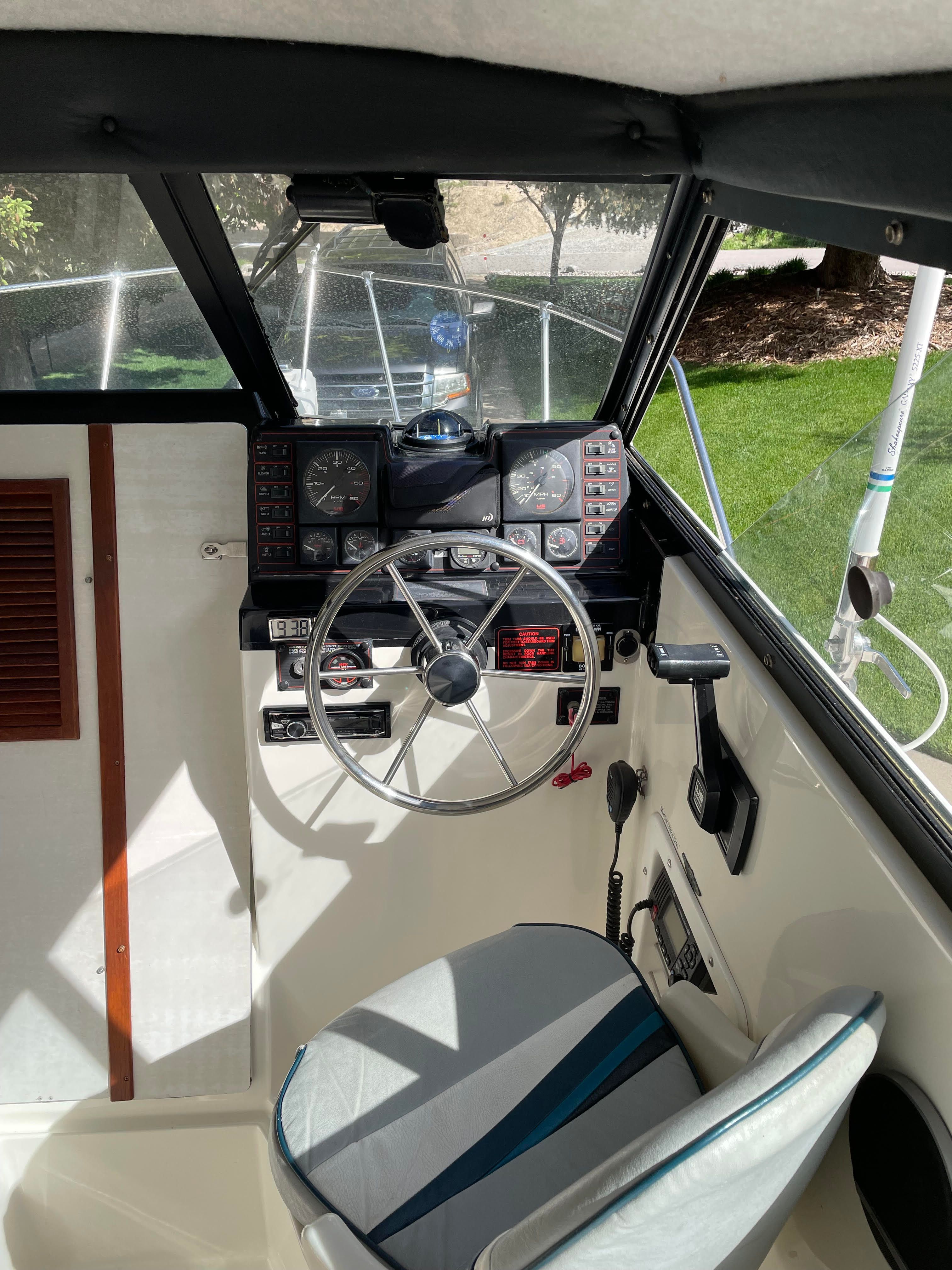 The cockpit of a 1991 Bayliner 2159 with steering wheel and instrument panel.