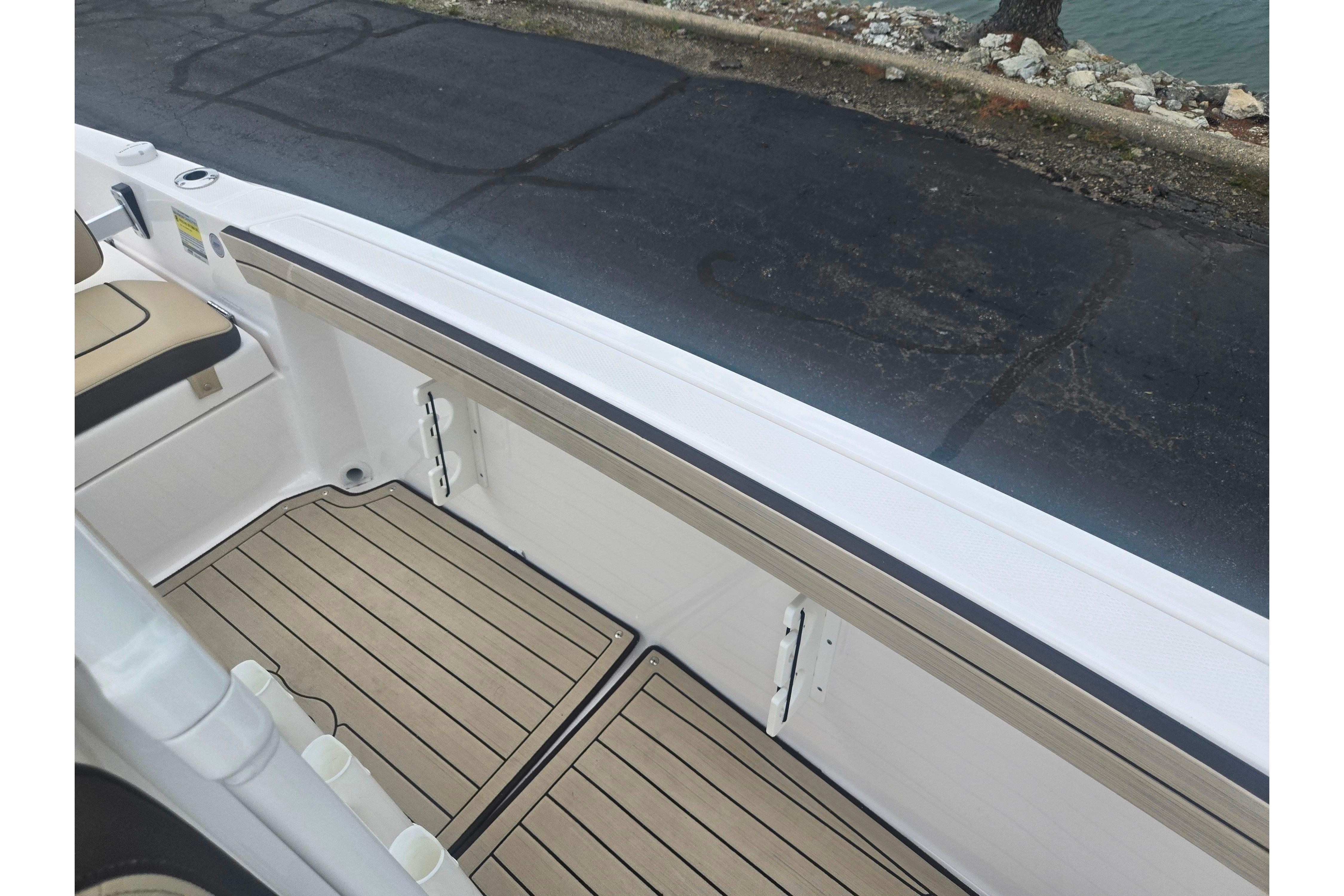 2022 Yamaha Boats 195 FSH Sport interior with sleek seating and wood-patterned flooring.