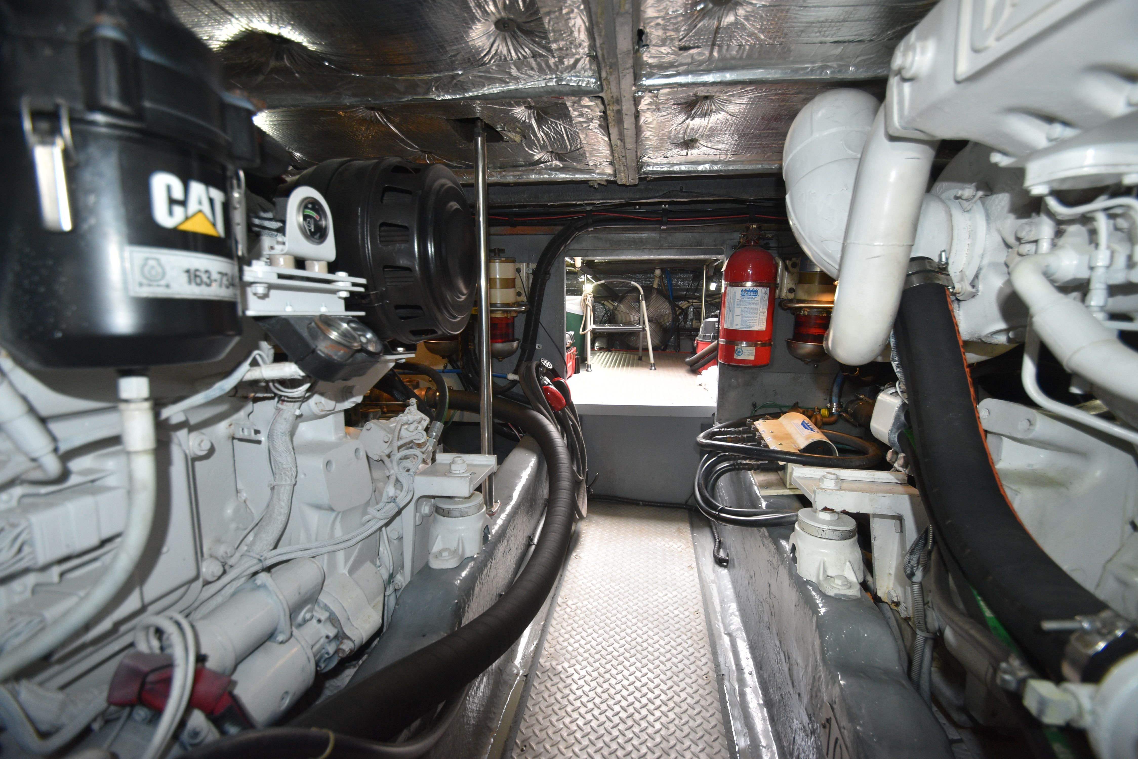 Engine room of a 2000 Sea Ray 480 Sedan Bridge with CAT engines and fire extinguisher.