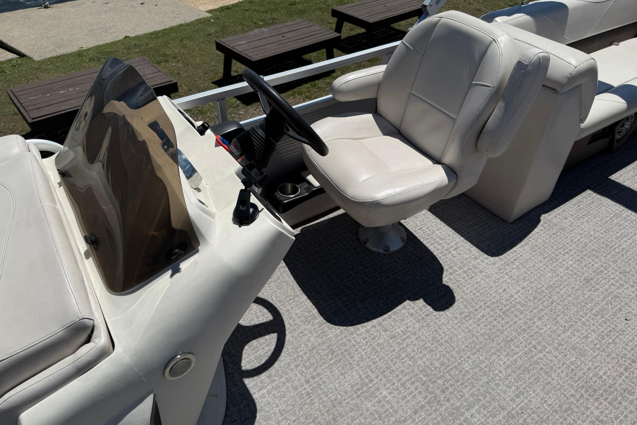2019 Avalon GS Quad Lounge boat interior with captain's chair and steering console.