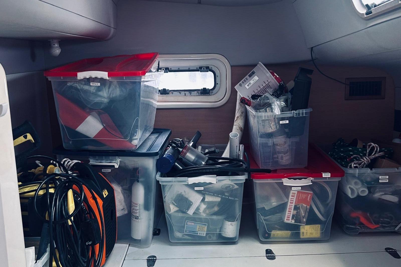 Storage area in a 2001 Robertson & Caine Leopard boat with organized plastic bins.