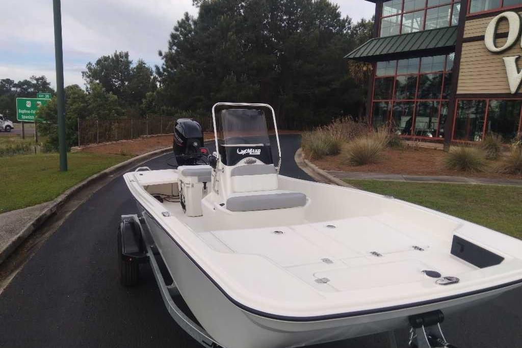 2026 Mako Pro Skiff 15 CC boat parked near a building and trees.
