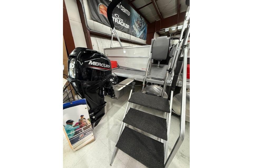 2026 Sun Tracker Party Barge 16 DLX with Mercury outboard motor in showroom.