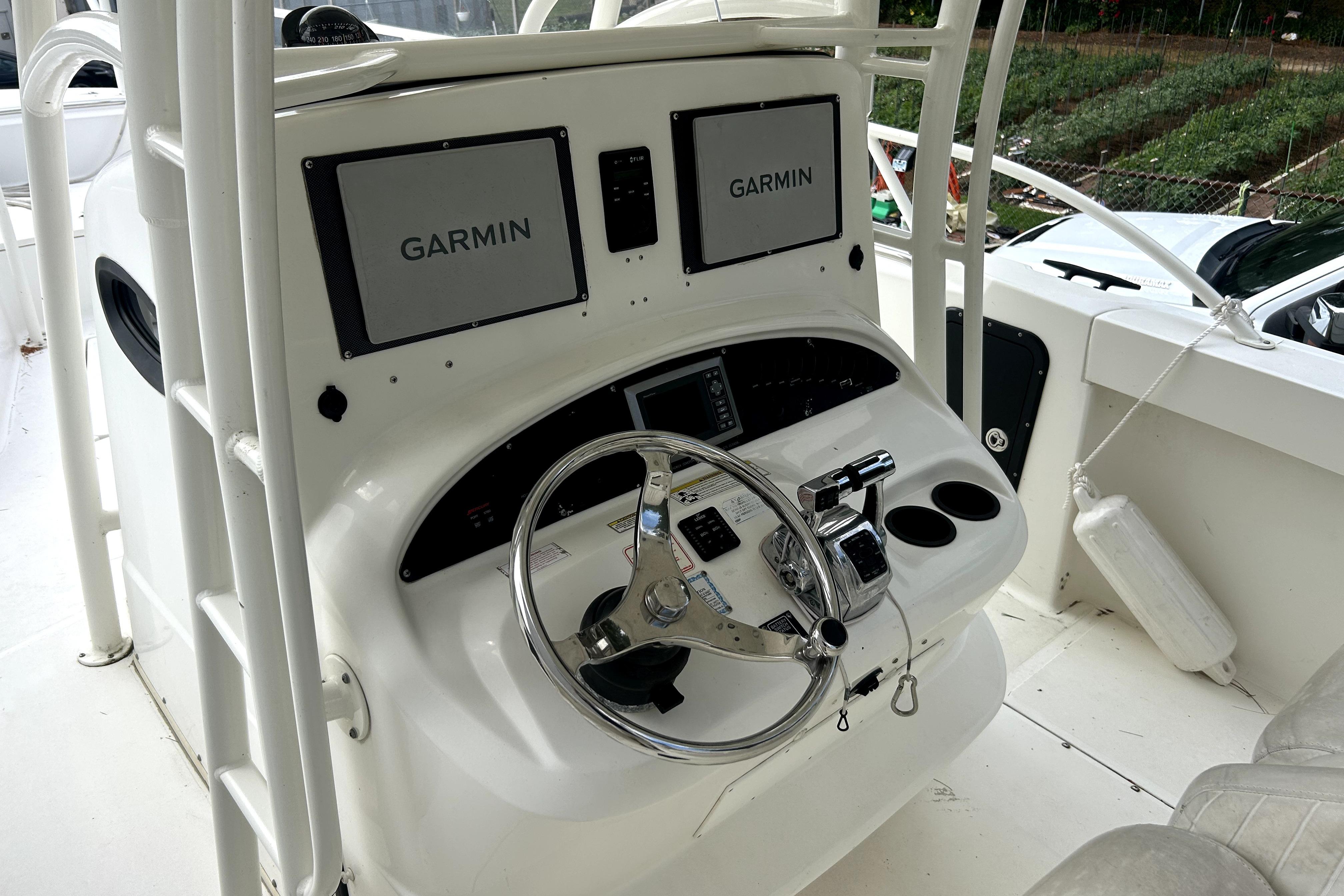 2012 Boston Whaler 320 Outrage helm with dual Garmin displays and steering wheel.