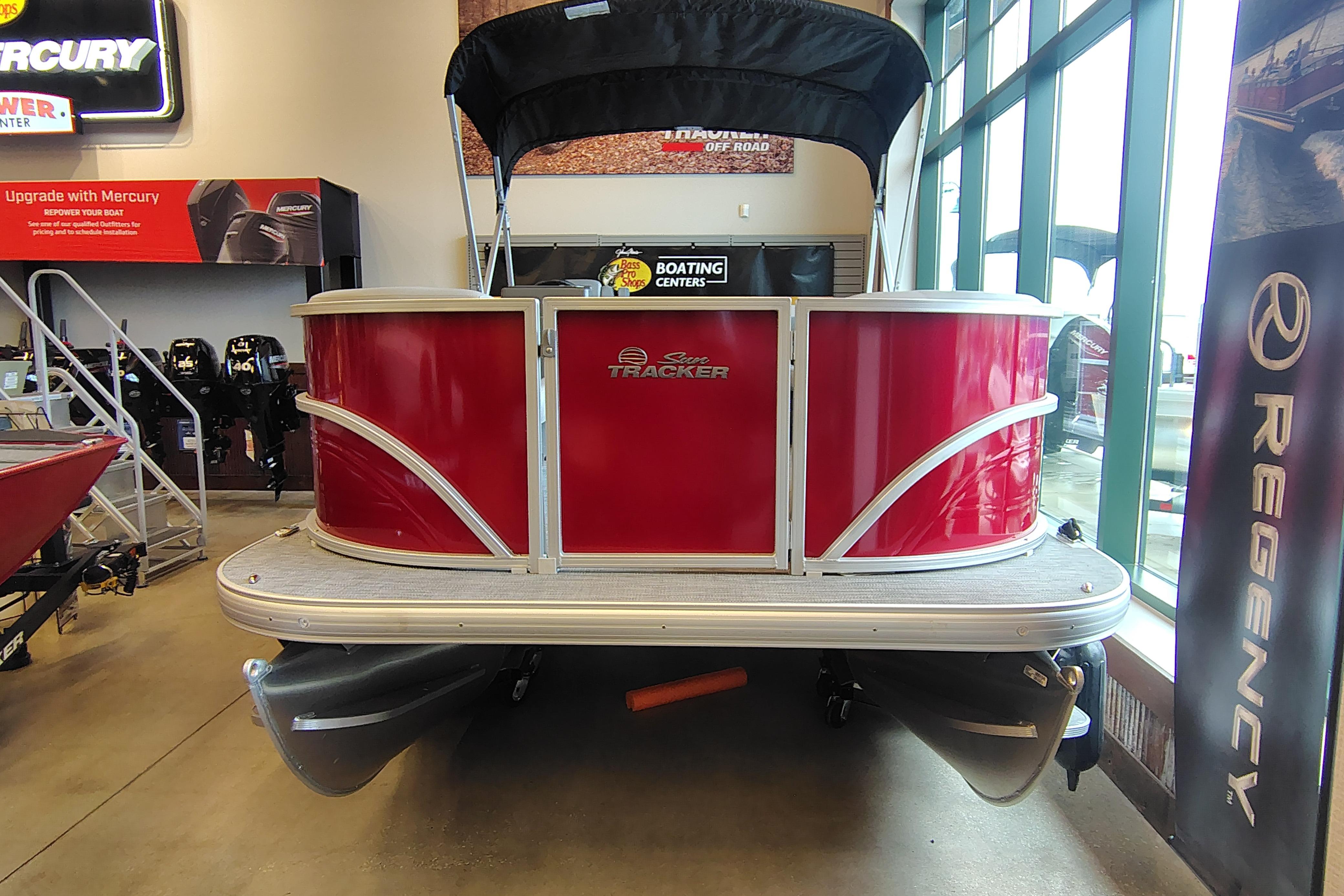 2026 Sun Tracker Party Barge 16 DLX pontoon boat displayed indoors, featuring a vibrant red exterior.