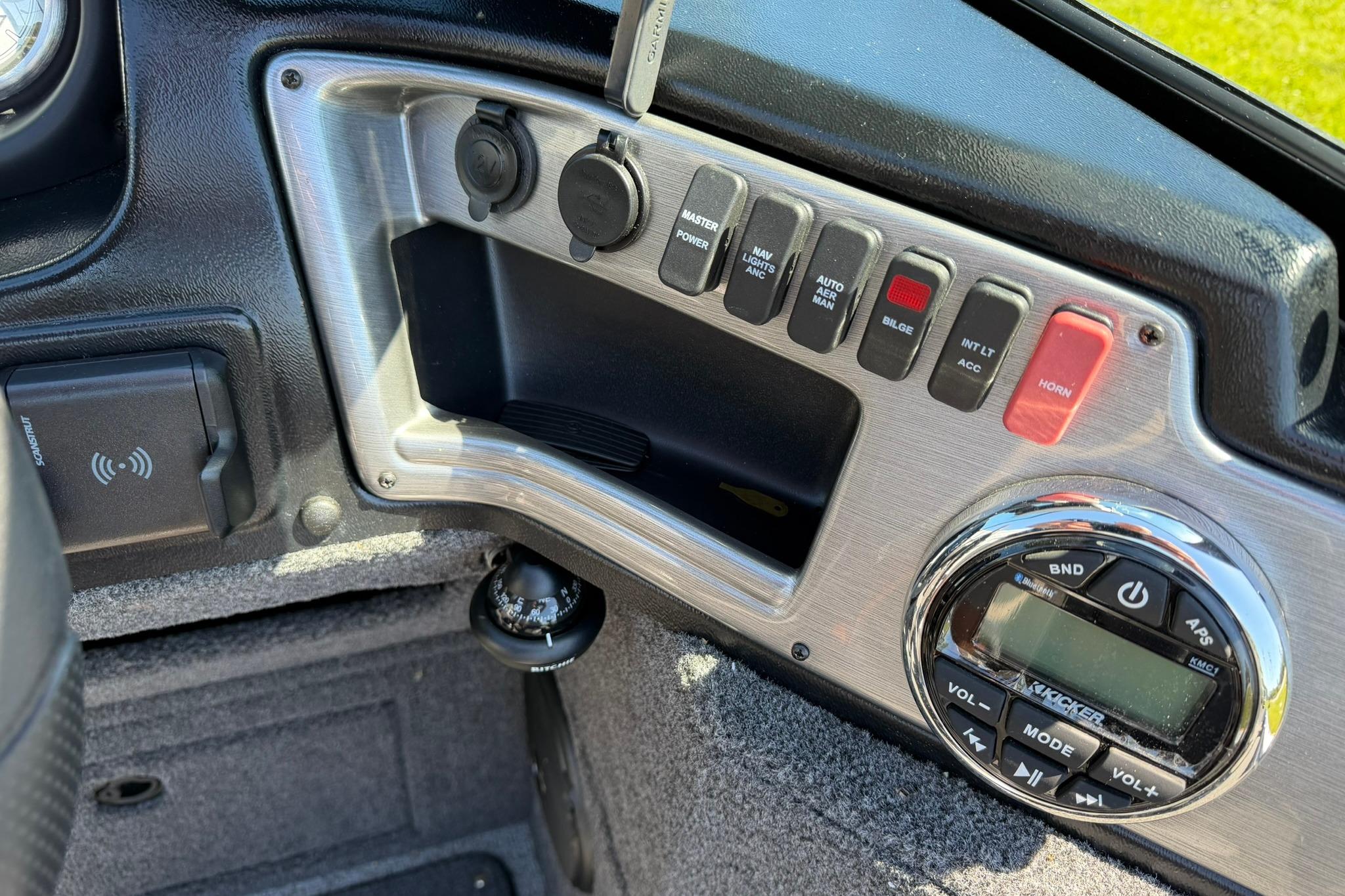 Dashboard controls of 2024 Lund 1875 Impact XS Sport boat, featuring switches and audio system.