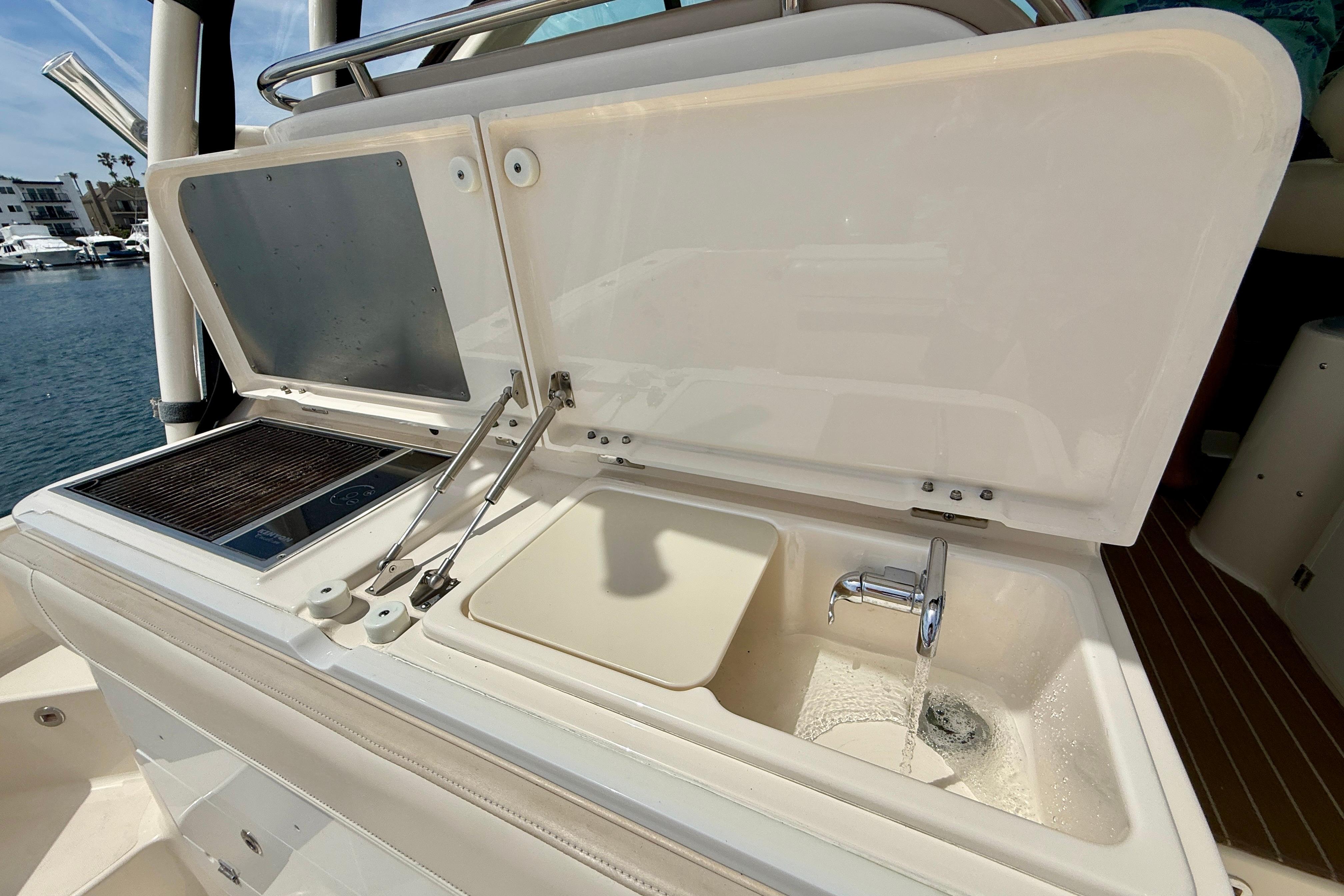 Outdoor kitchen on 2012 Pursuit OS 345 Offshore boat with sink and grill.