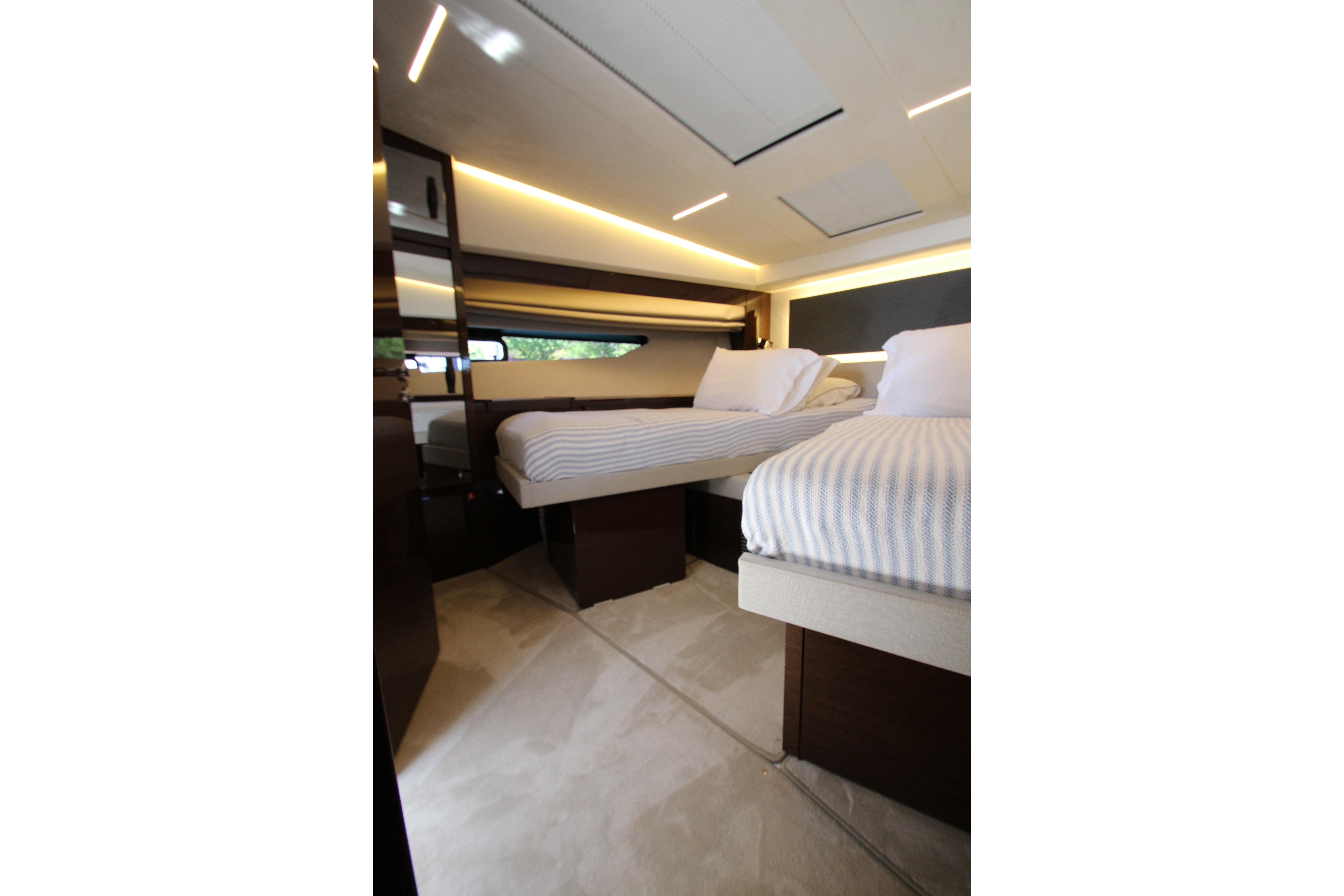 Luxurious interior of 2022 Prestige 520 yacht with twin beds and modern lighting.