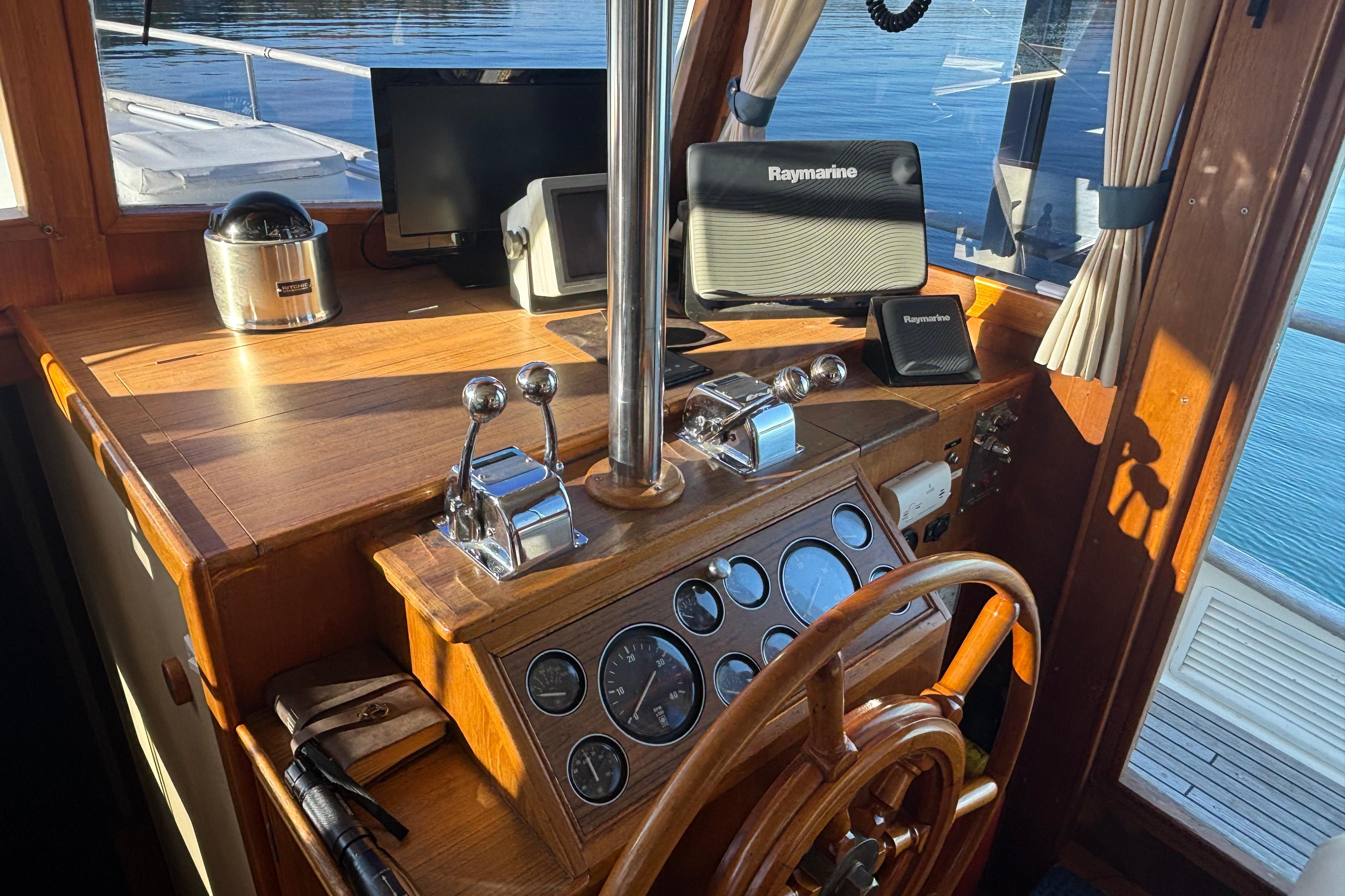 Helm of 1989 Grand Banks 46 Classic yacht with Raymarine navigation equipment.