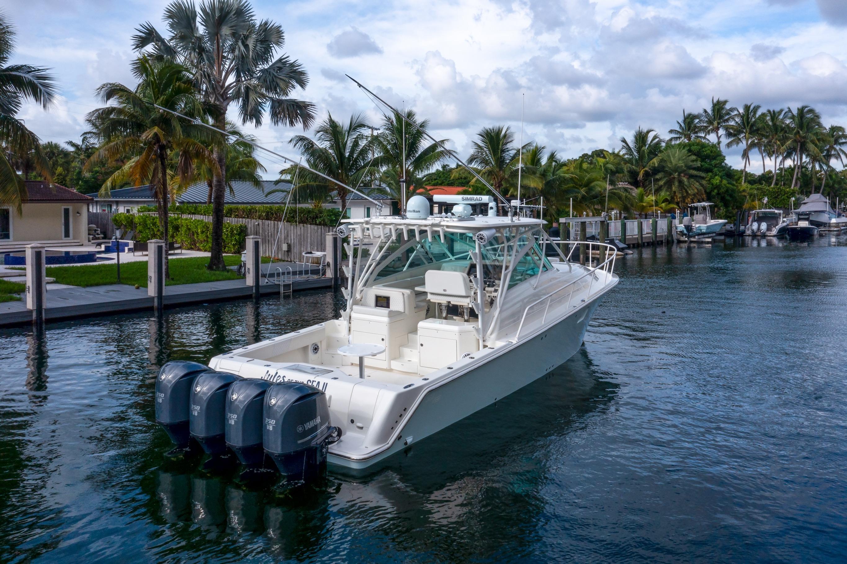 2011 SeaVee 430 Sport Express boat docked, surrounded by palm trees and waterfront homes.