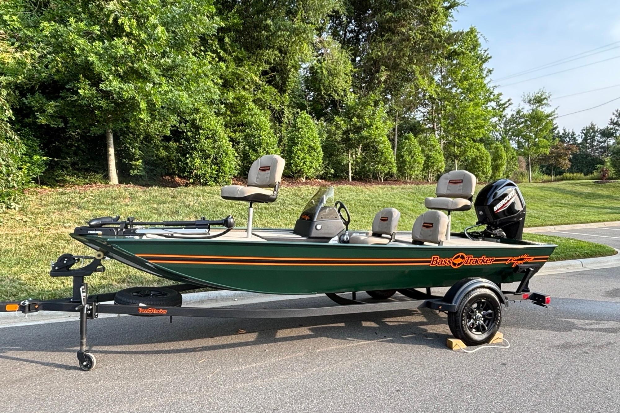2026 Tracker Bass Tracker Classic Limited boat on trailer, parked on a road with lush greenery.