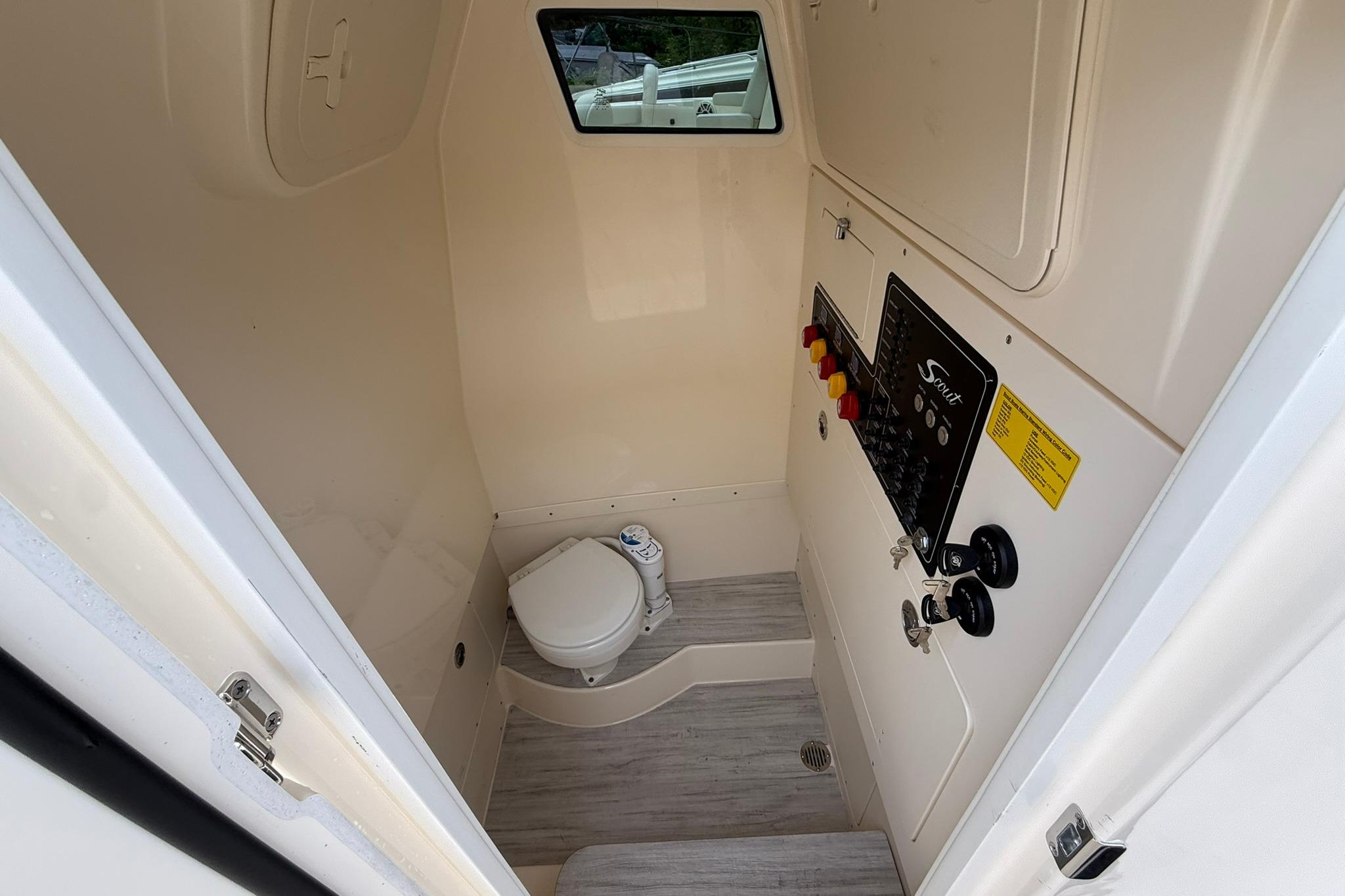 Interior of 2026 Scout 260 LXF boat featuring a compact marine toilet.