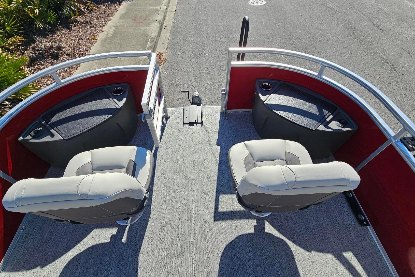 2026 Sun Tracker Fishin' Barge 22 DLX interior with two seats and red railing.