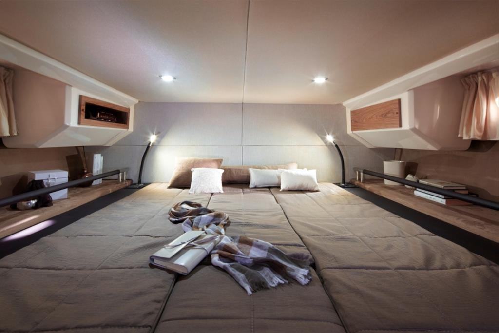 Luxurious cabin interior of 2013 Sessa Marine Key Largo 34 with cozy bedding and ambient lighting.