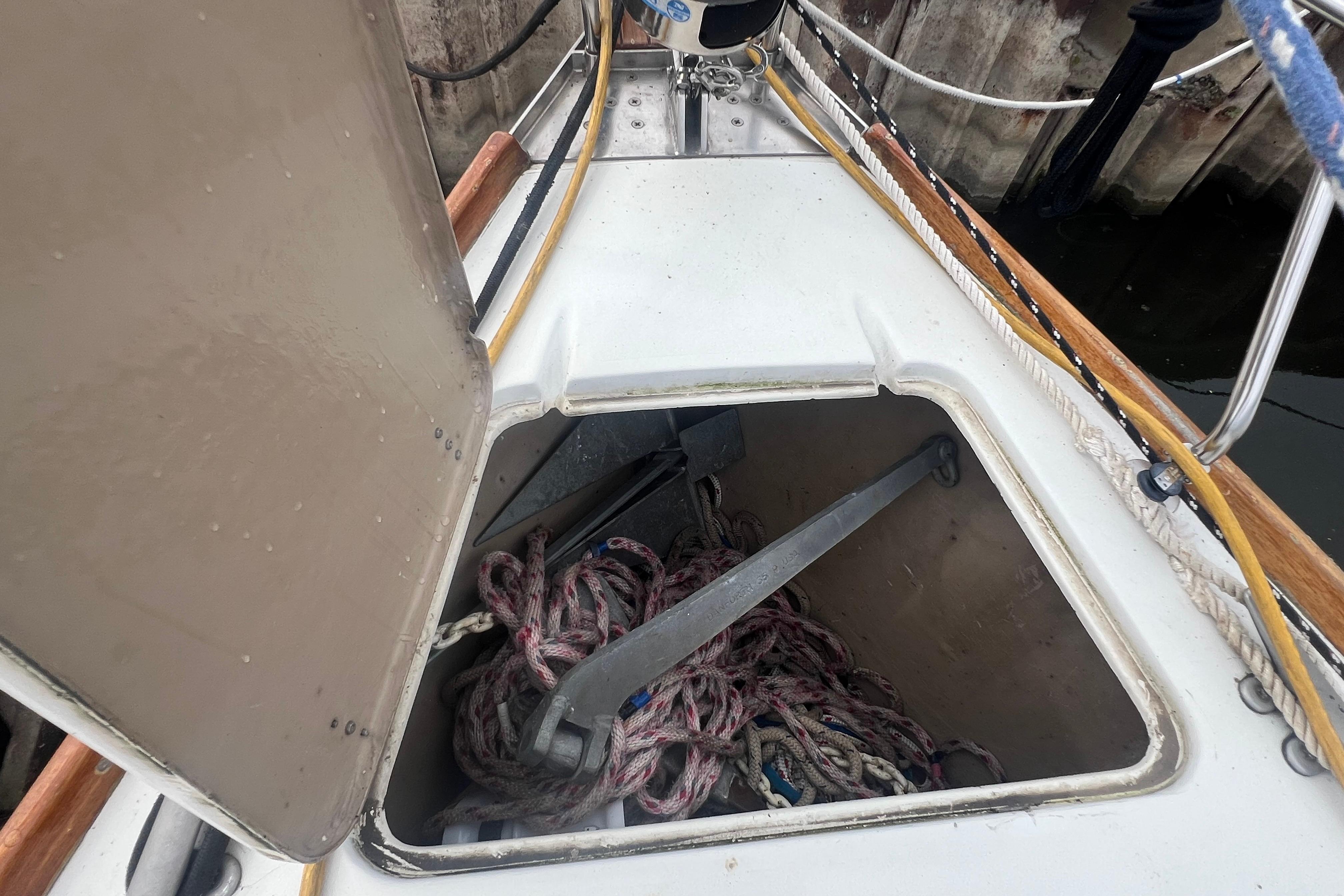 Open anchor locker on 1985 C&C Landfall 39 sailboat, showing ropes and anchor.
