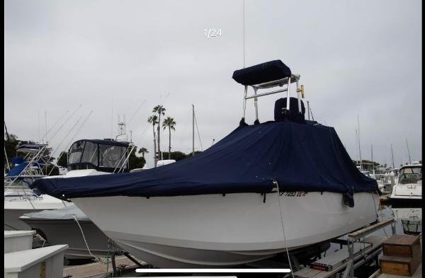 1979 Chaparral 224 Fisherman boat covered at marina dock.