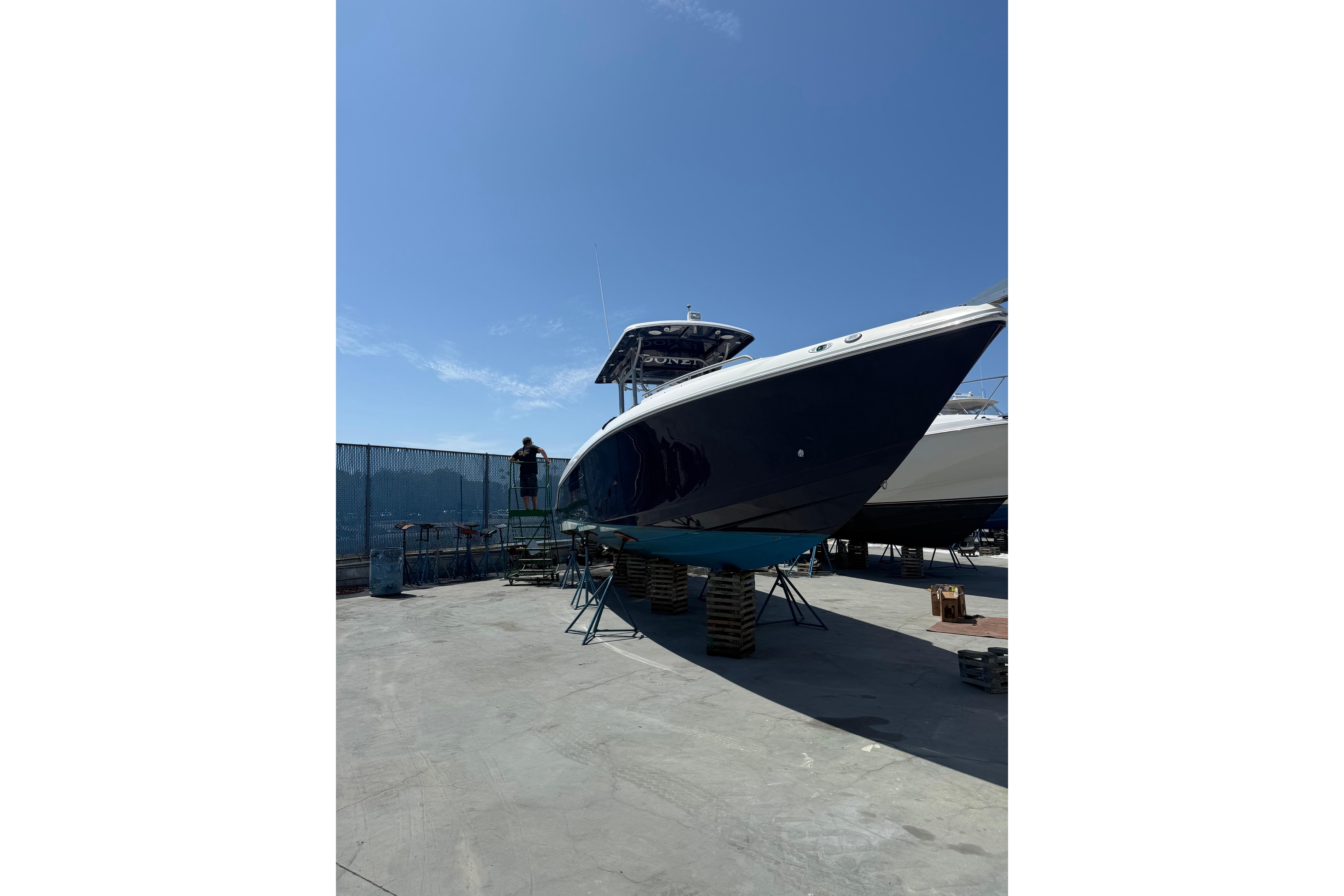 2011 Donzi 38 ZFX Open boat on dry dock under clear blue sky.