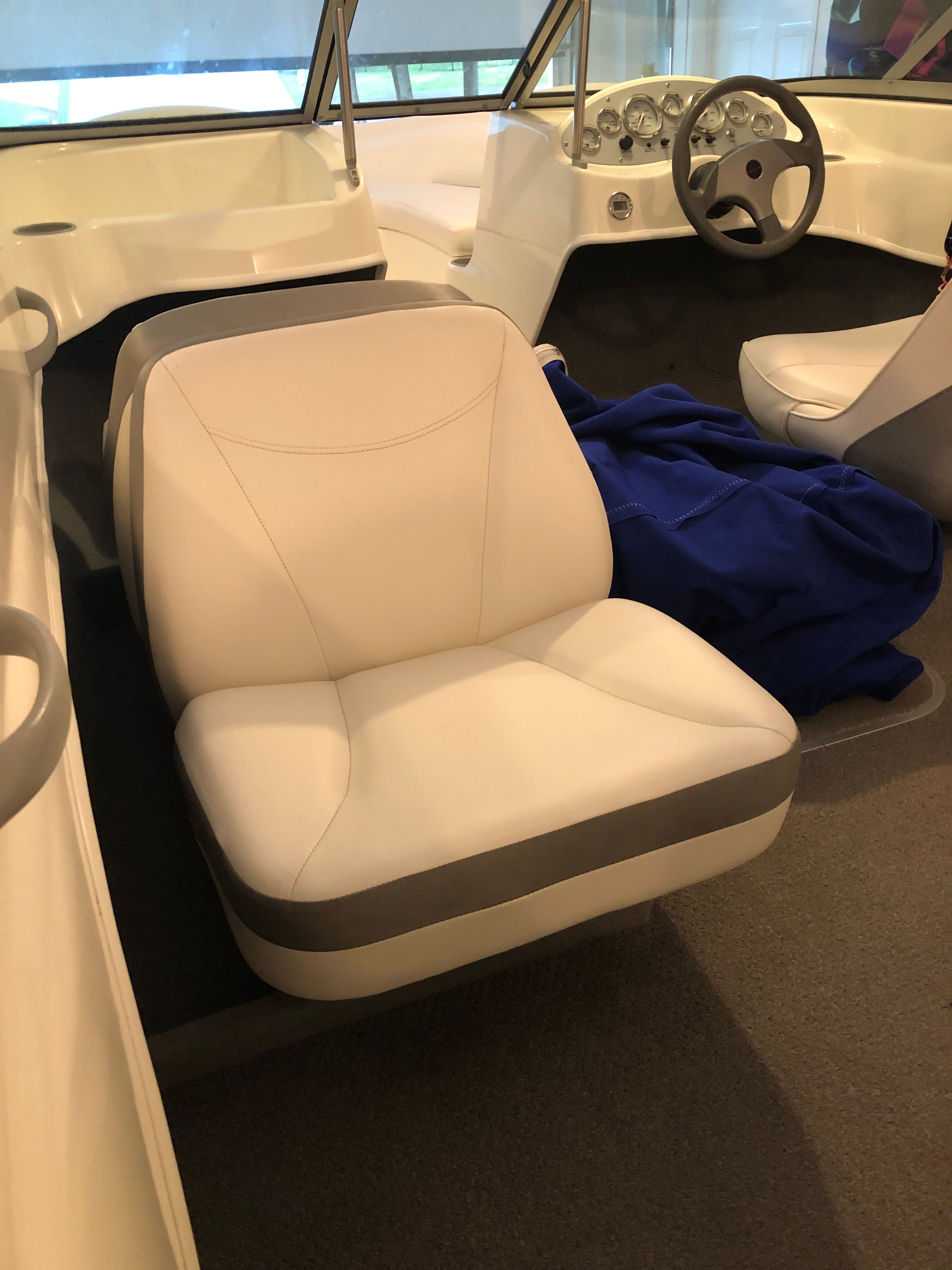 Interior view of a Bayliner 175 Bowrider with white seats and a steering wheel.