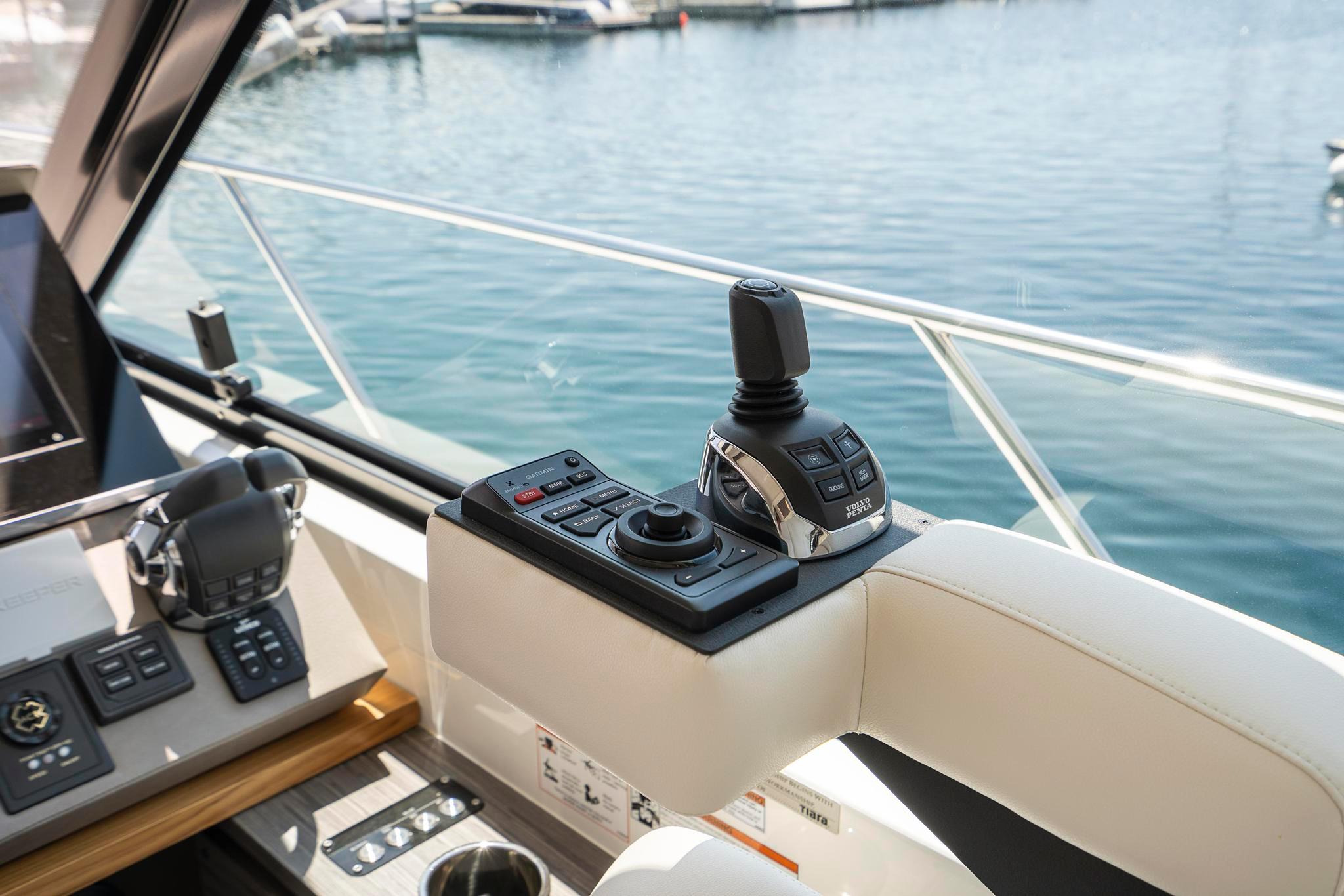 Control panel of 2022 Tiara Yachts C49 Coupe overlooking marina waters.